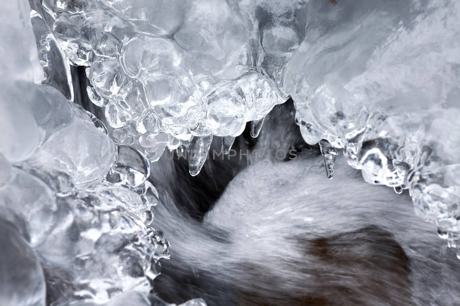 Ice background of a small stream in winter