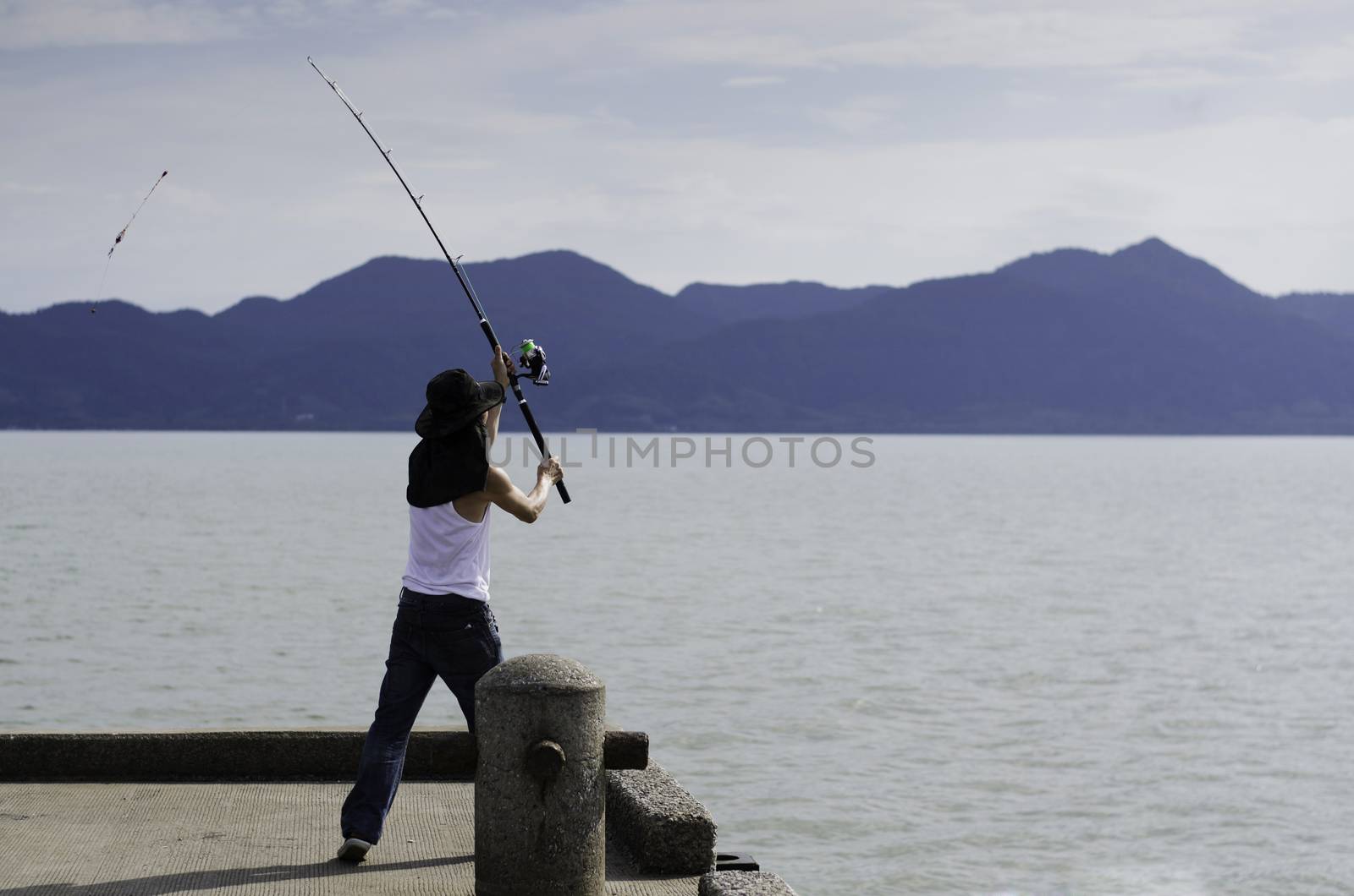 Fisherman fishing trolling in the sea by siraanamwong