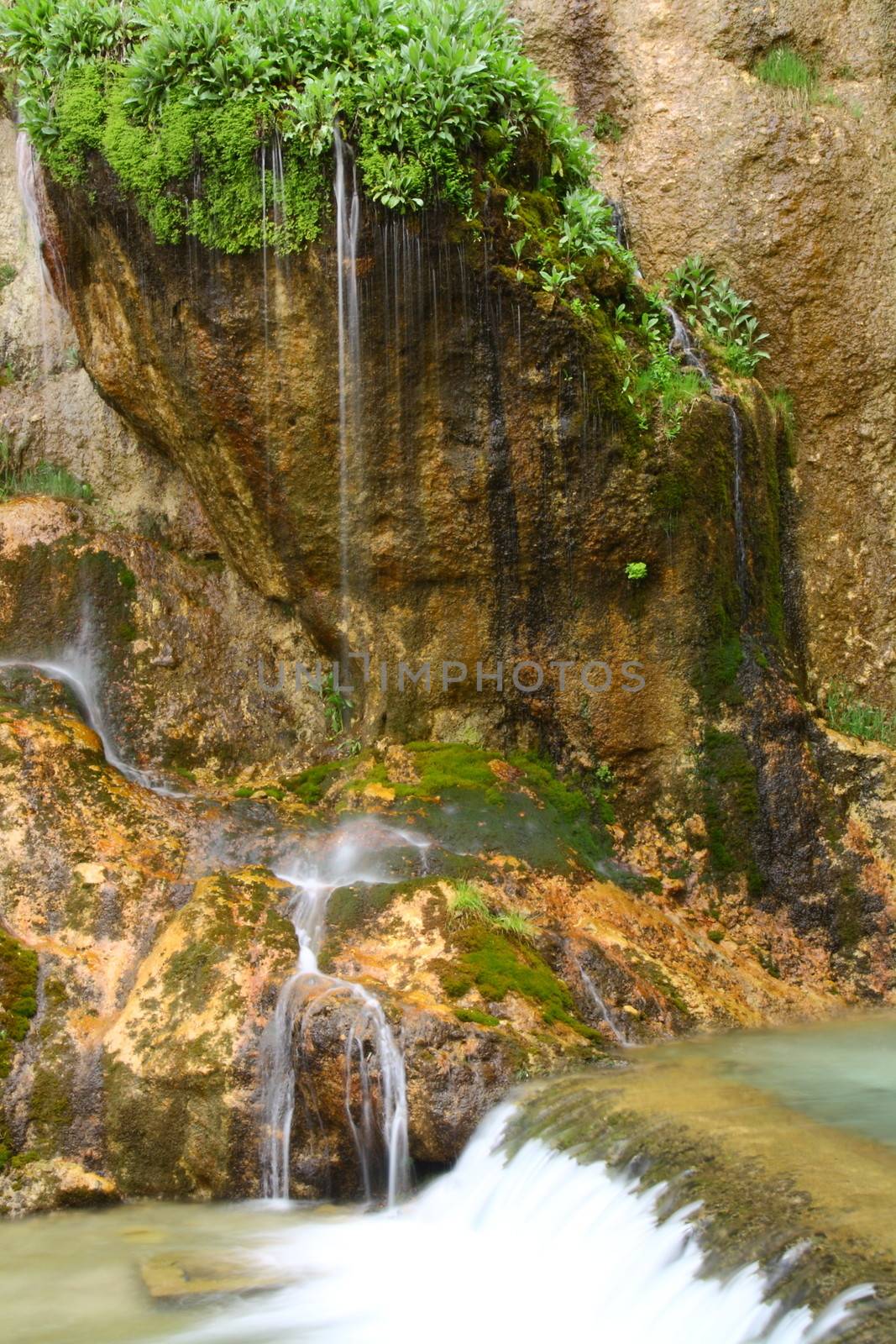 water falling to river between huge rocks 