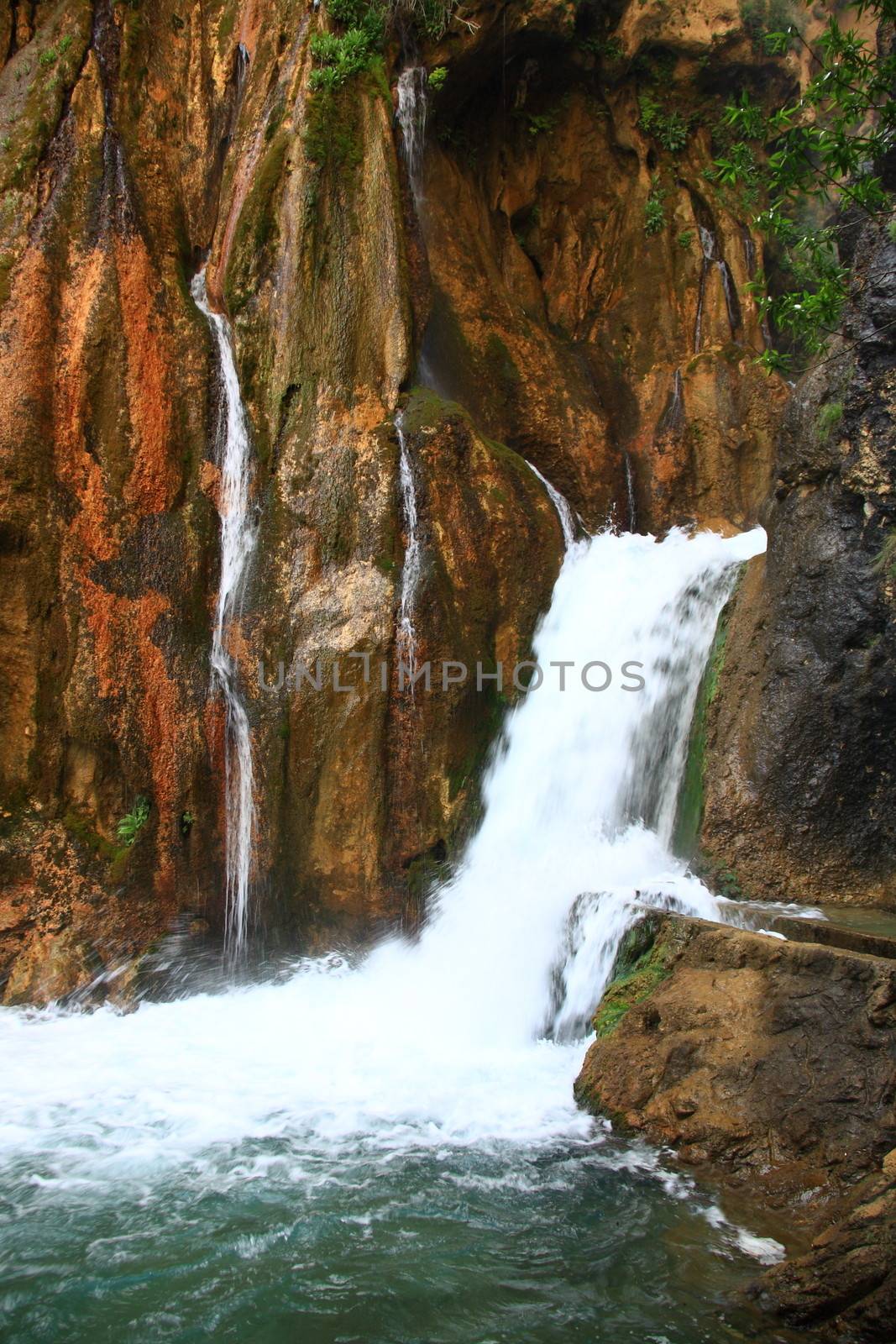 water falling to river between huge rocks 