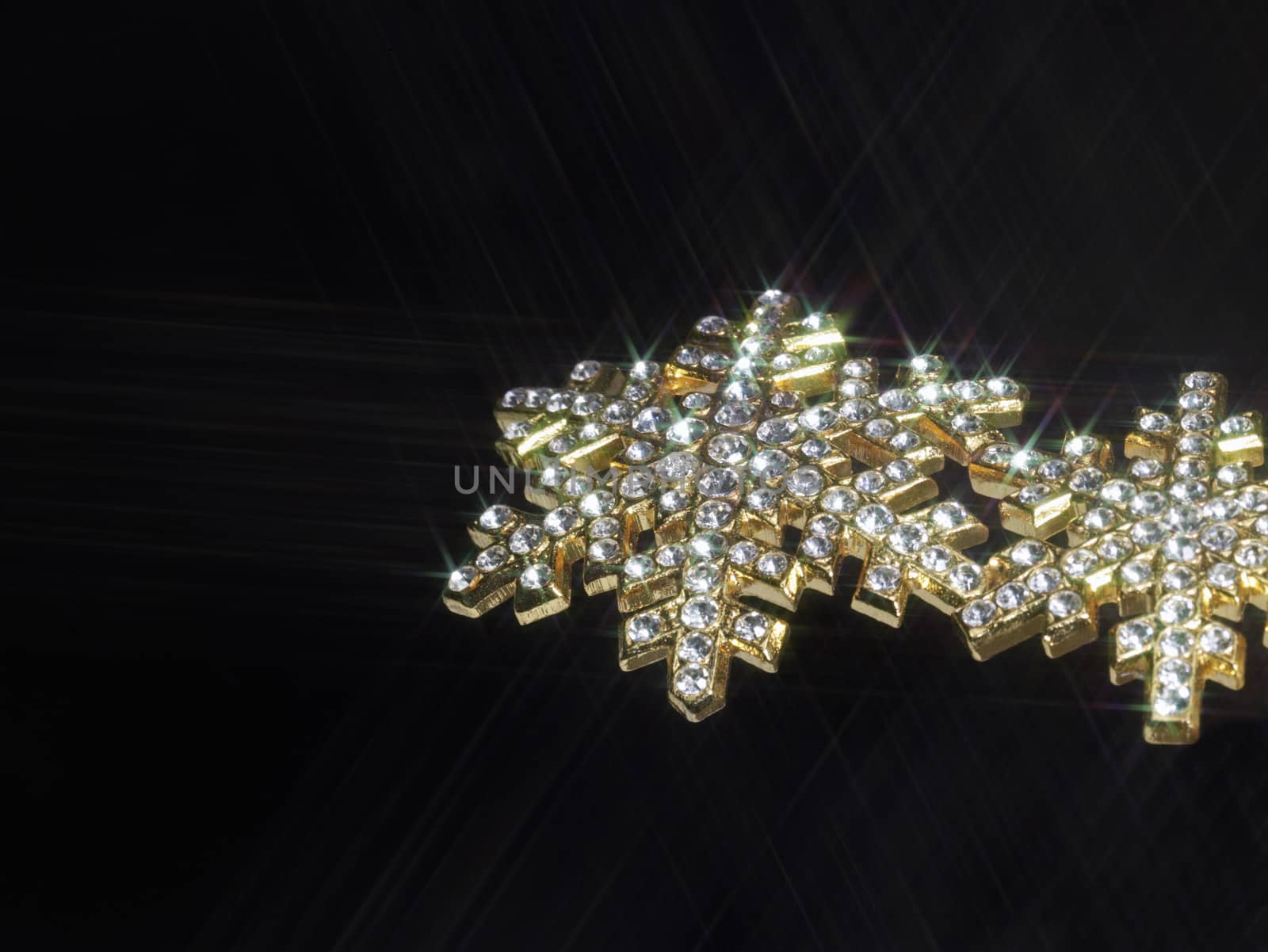 shiny jewelry in dark back, effective illuminated with a optical star-filter