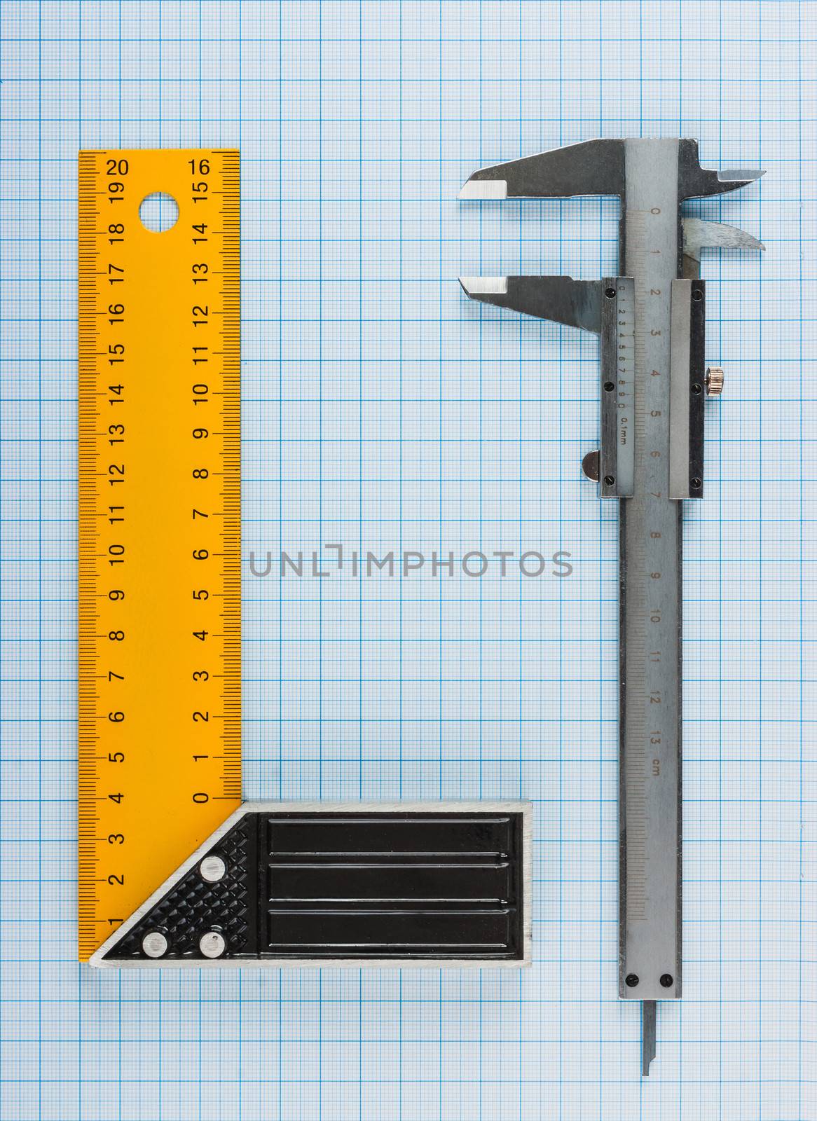 calipers, bearing and square on the background of graph paper