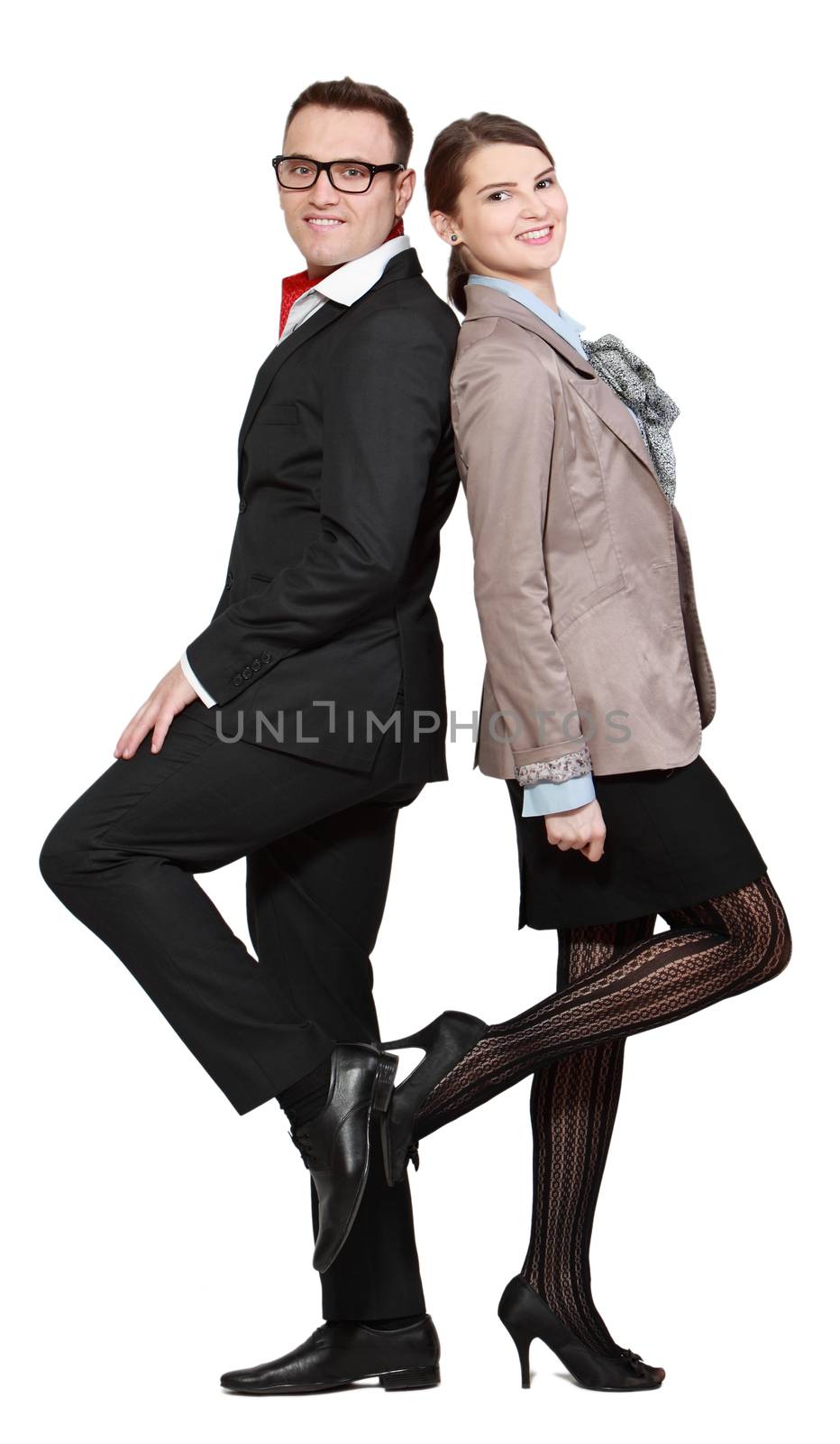 Happy casual young couple posing back in back against a white background.