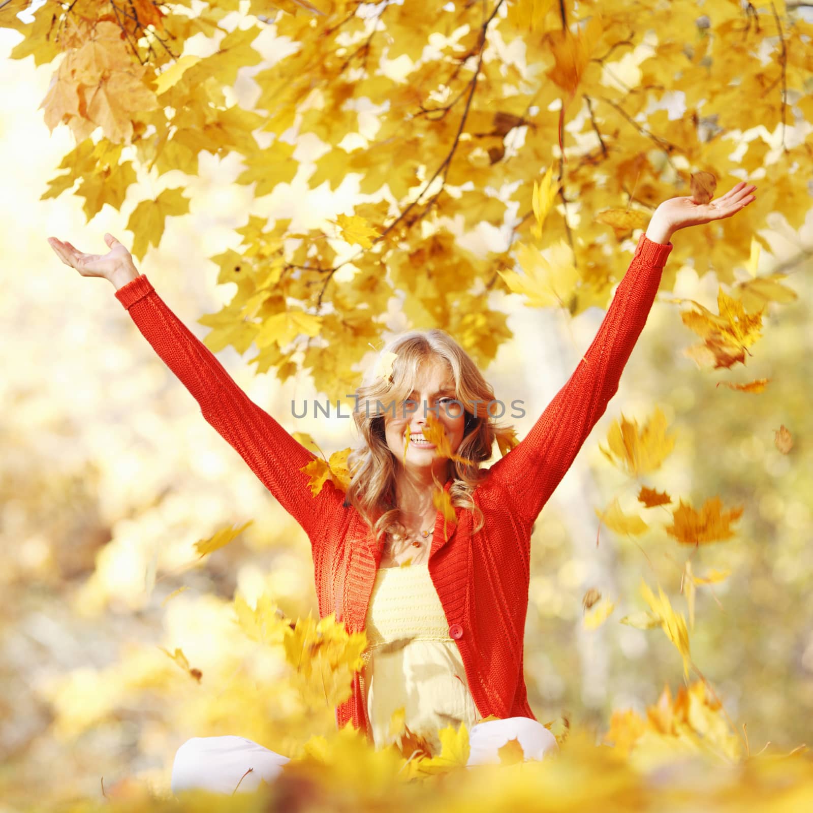 Happy woman in autumn park drop up leaves