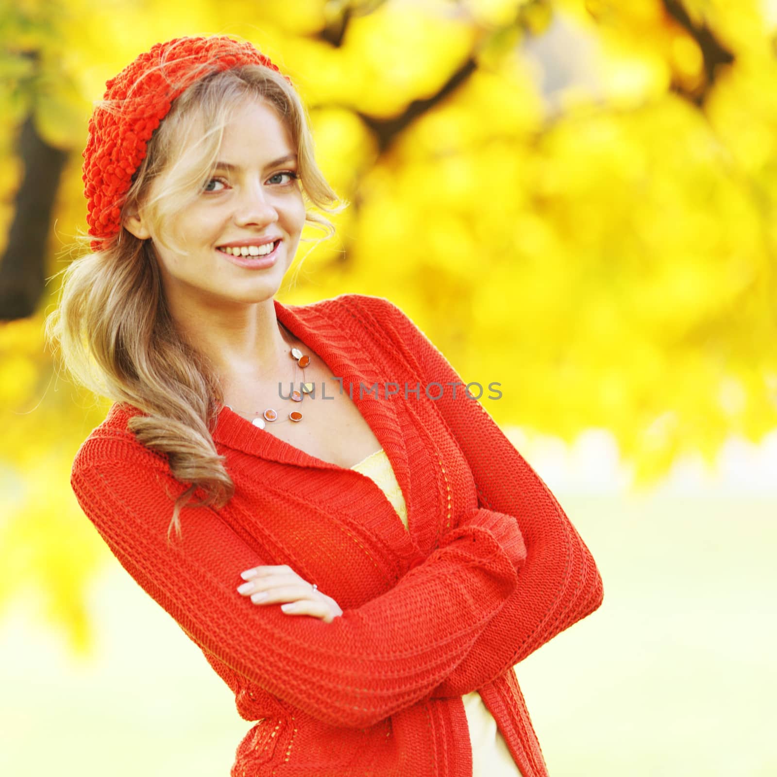 Beautiful young woman in red clothes in autrumn park