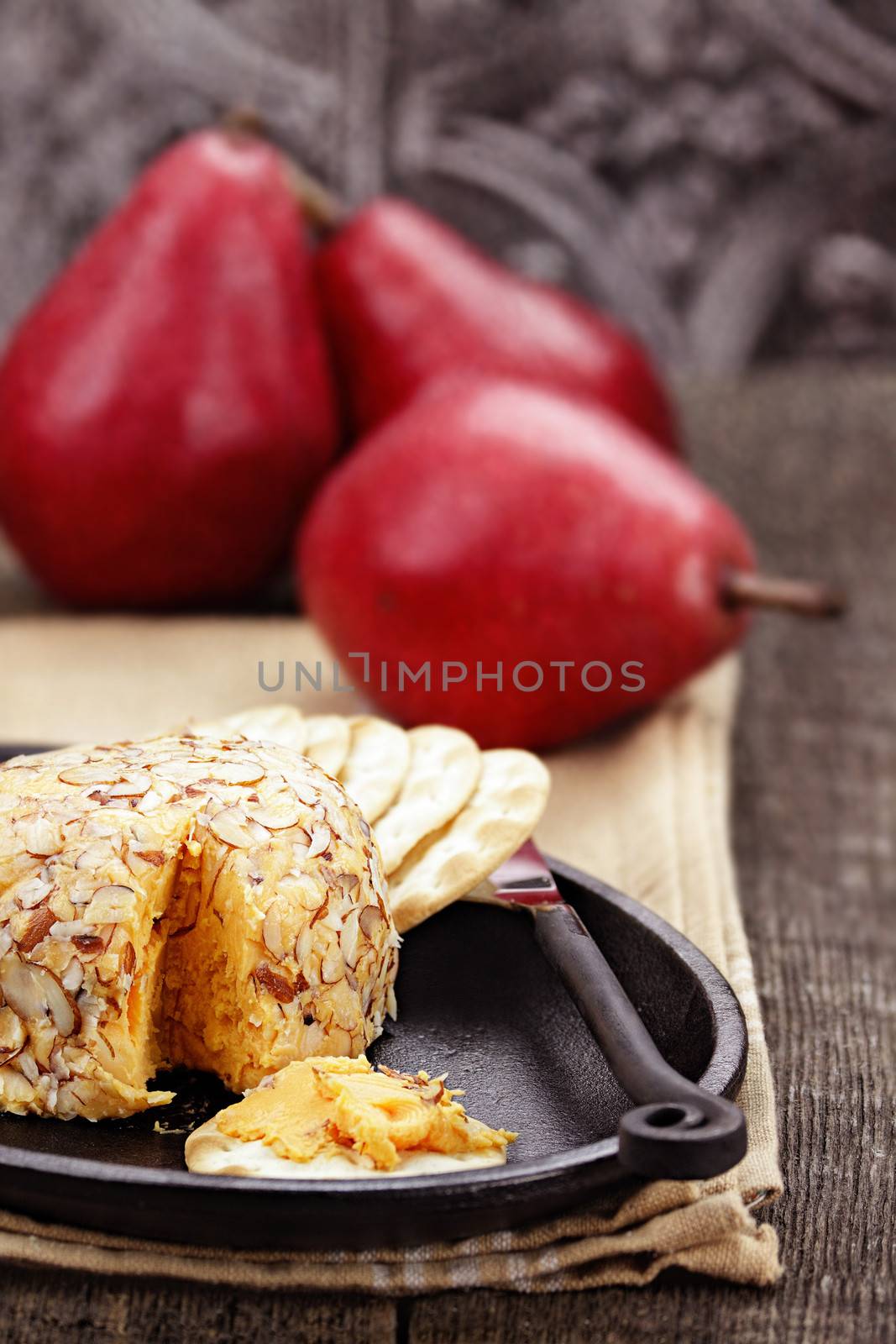 Cheese spread with almonds, crackers and red pears. 