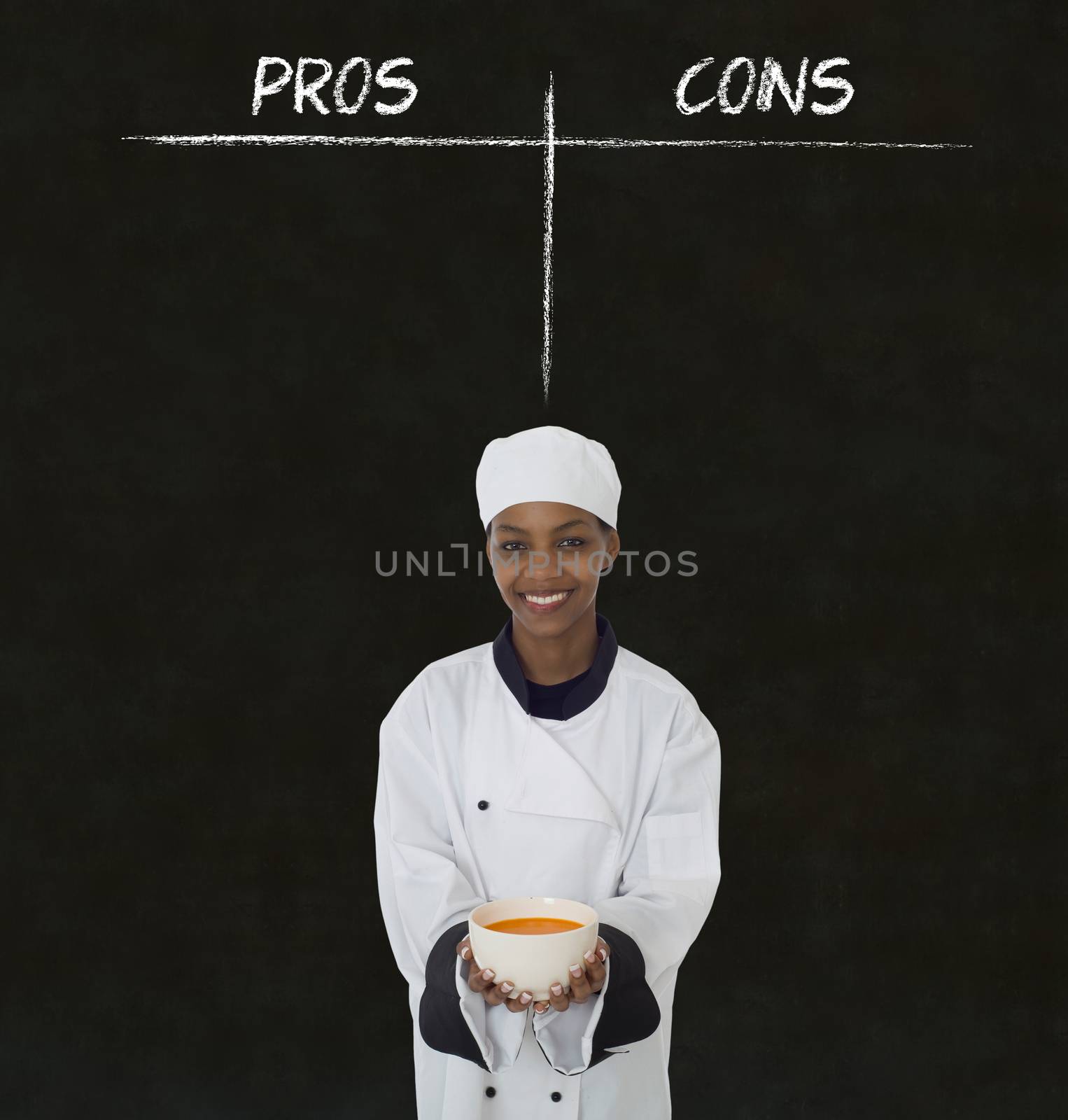 African American woman chef holding soup bowl with chalk pros and cons on blackboard background