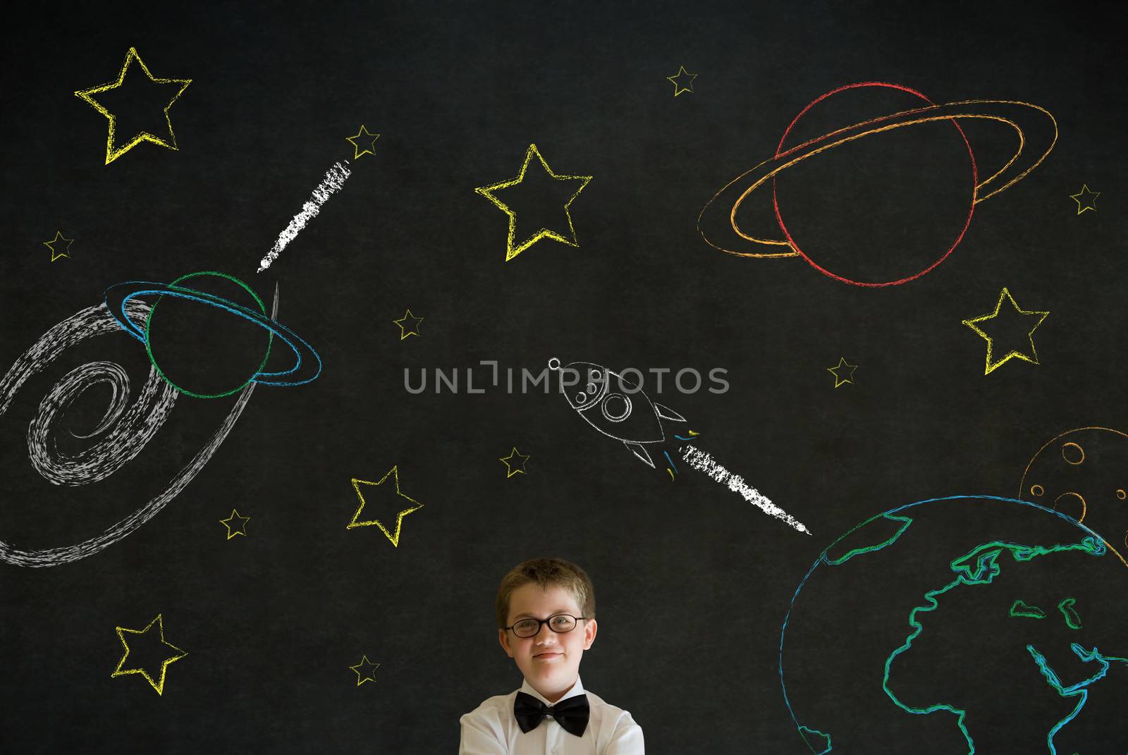 Thinking boy business man with chalk universe planet solar system on blackboard imagining space travel by alistaircotton