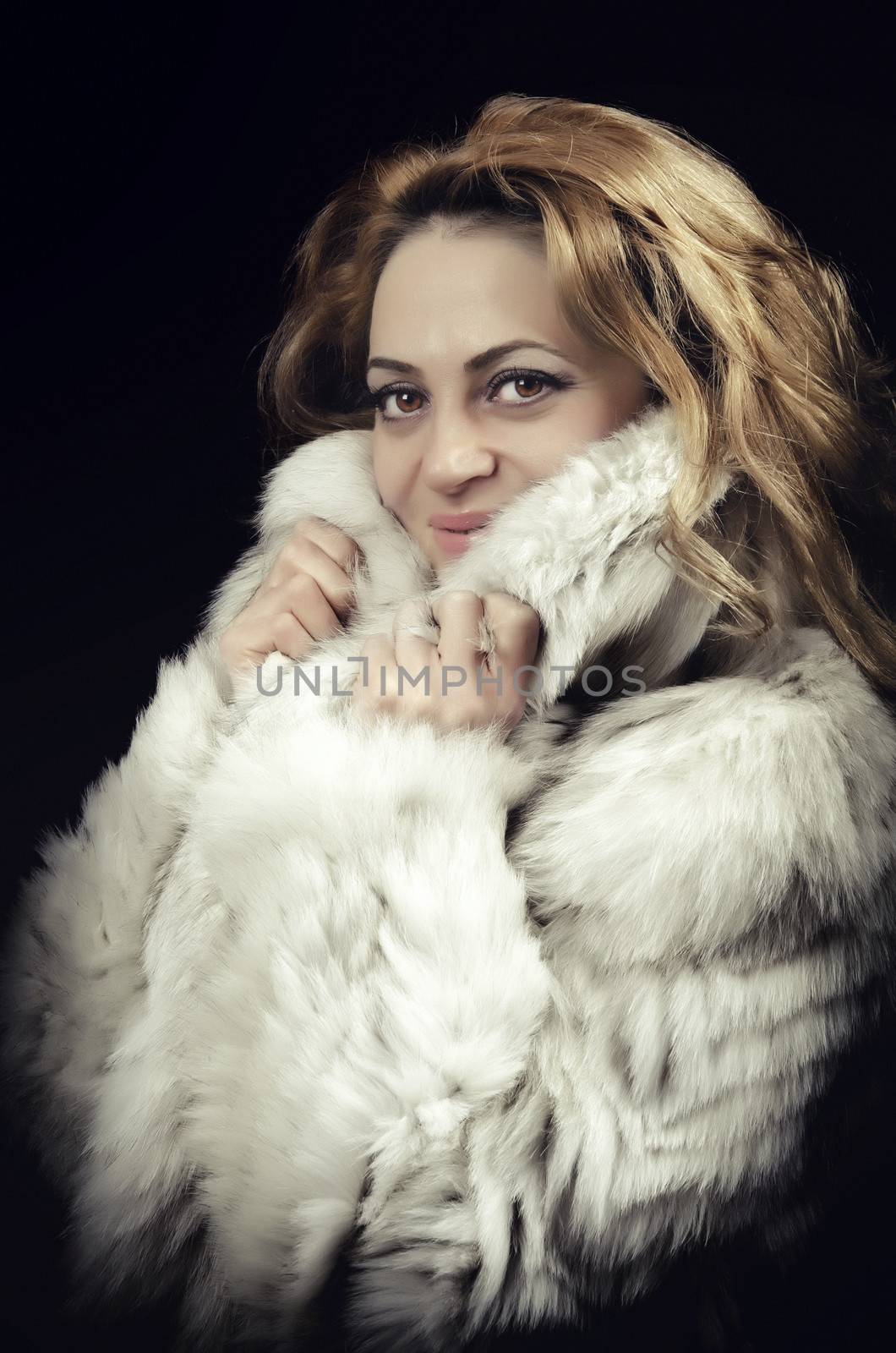 Model dressed in a fur coat smilling at camera
