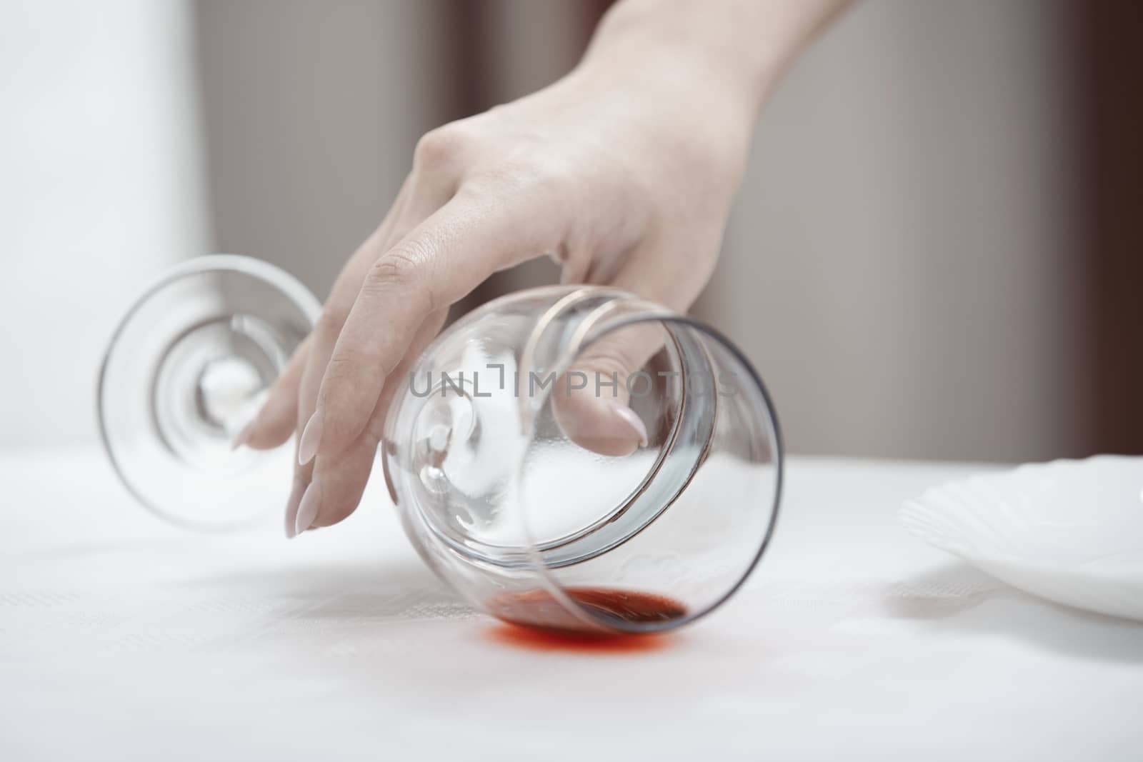 Human hand taking fallen wineglass