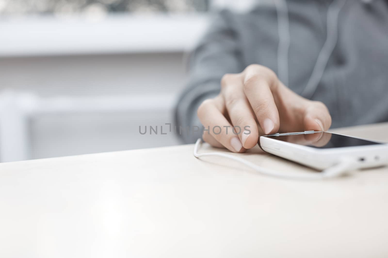 Hand of woman listening music from smartphone