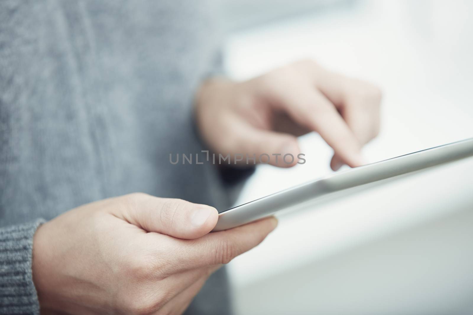 Woman with digital tablet surfing the web. Close-up view