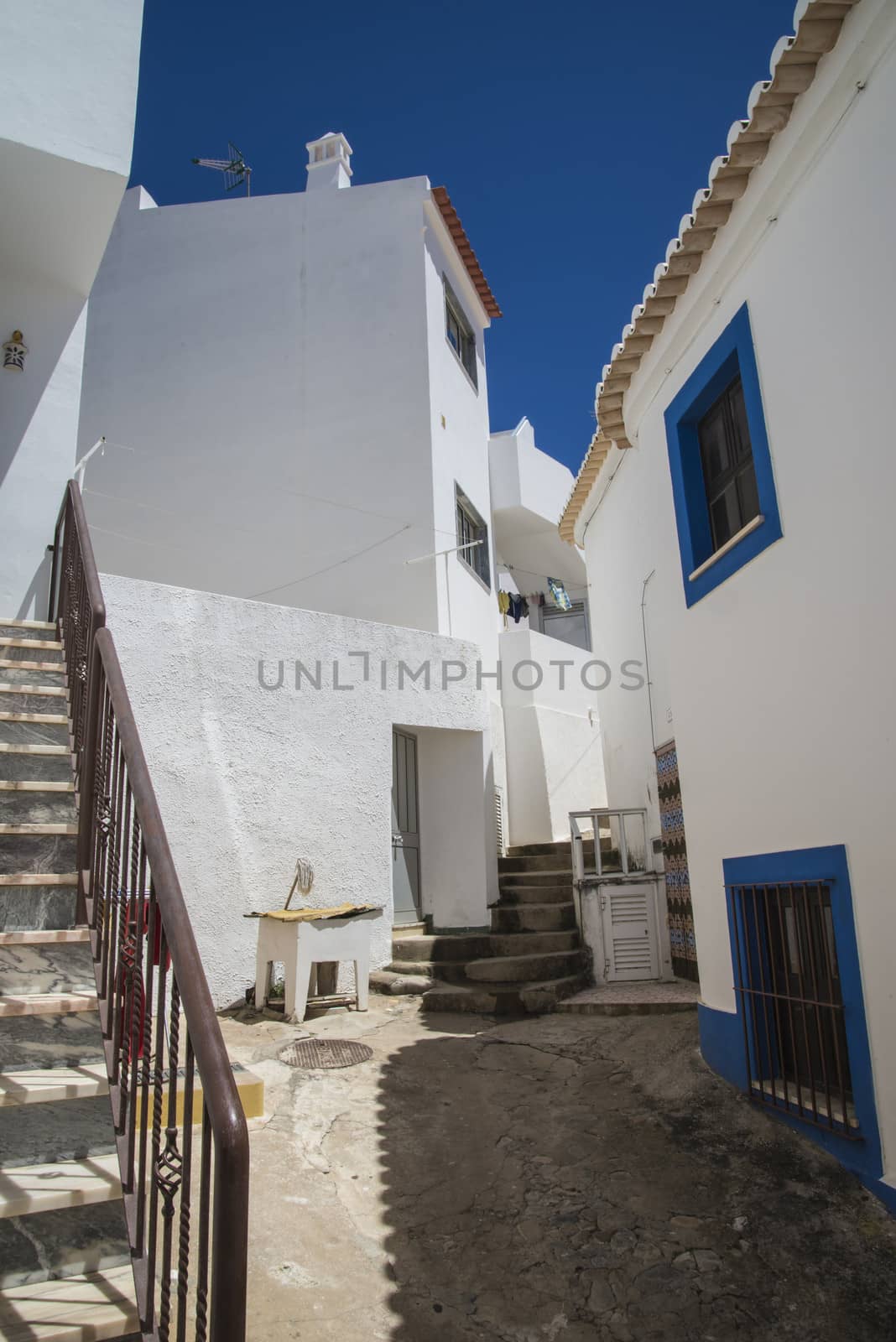 narrow streets and painted white houses in burgau by steirus