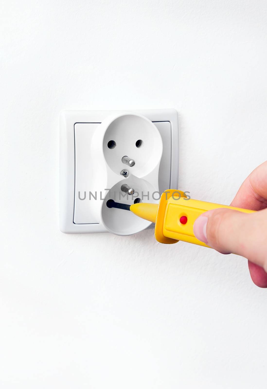 Man checking power in socket with detector