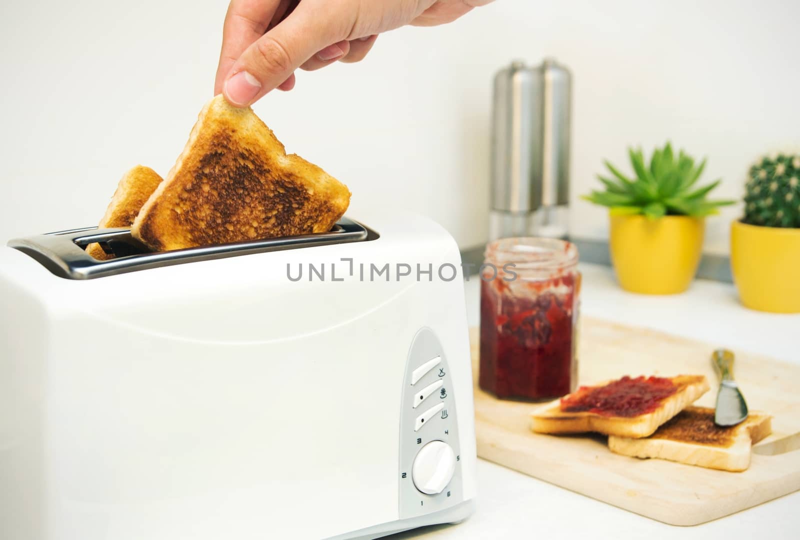 Breakfast prepare. Toaster and toast with jam in modern kitchen