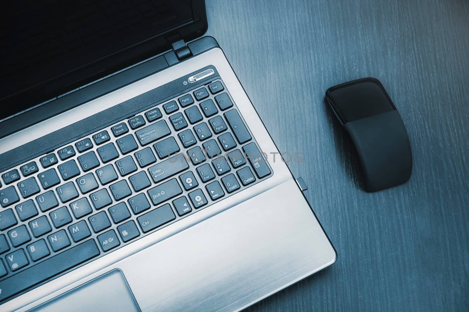 Laptop and modern flat mouse on wooden desk by simpson33