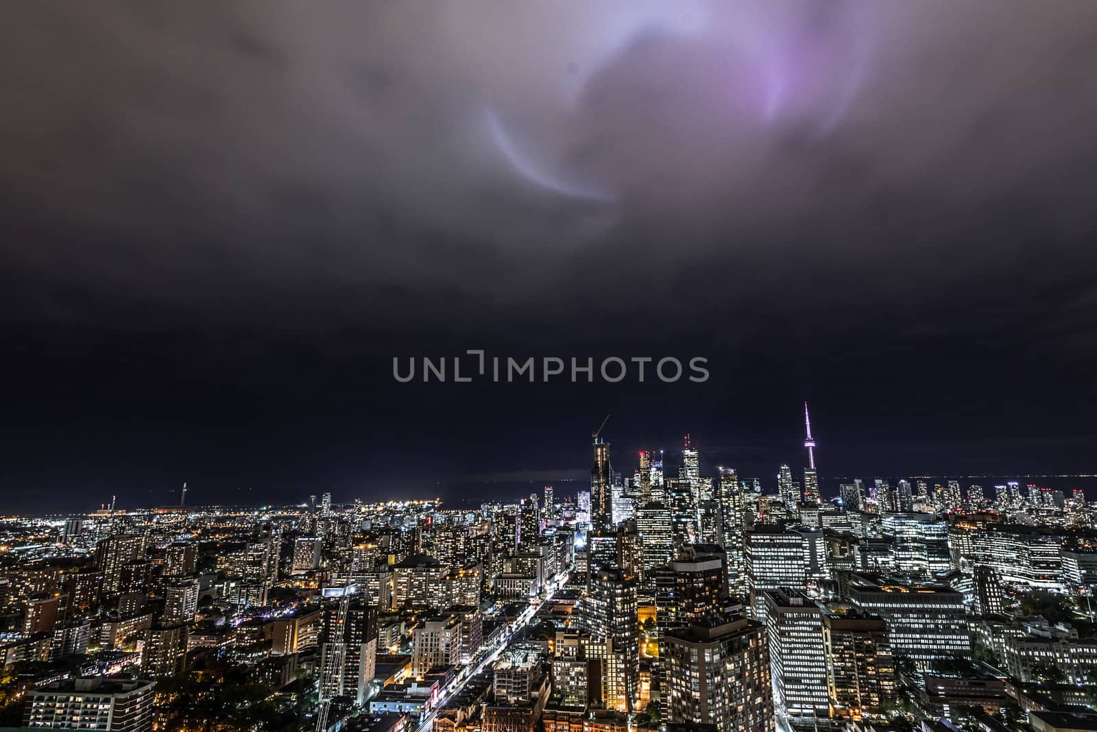 Full view of downtown Toronto at night with glamour spotlights pattern in the sky