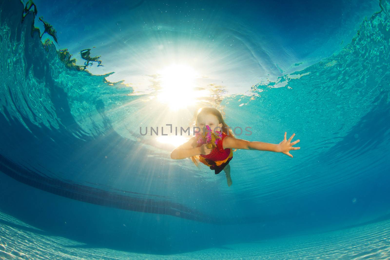 little girl underwater with bright flowers