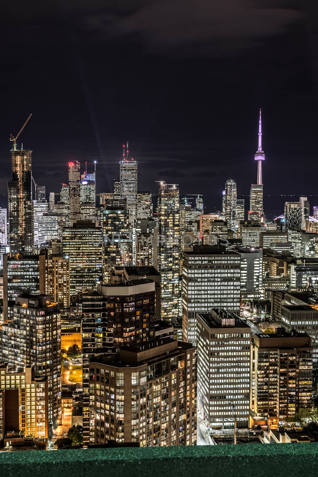 Full view of downtown Toronto at night with glamour lights viewing from a balcony