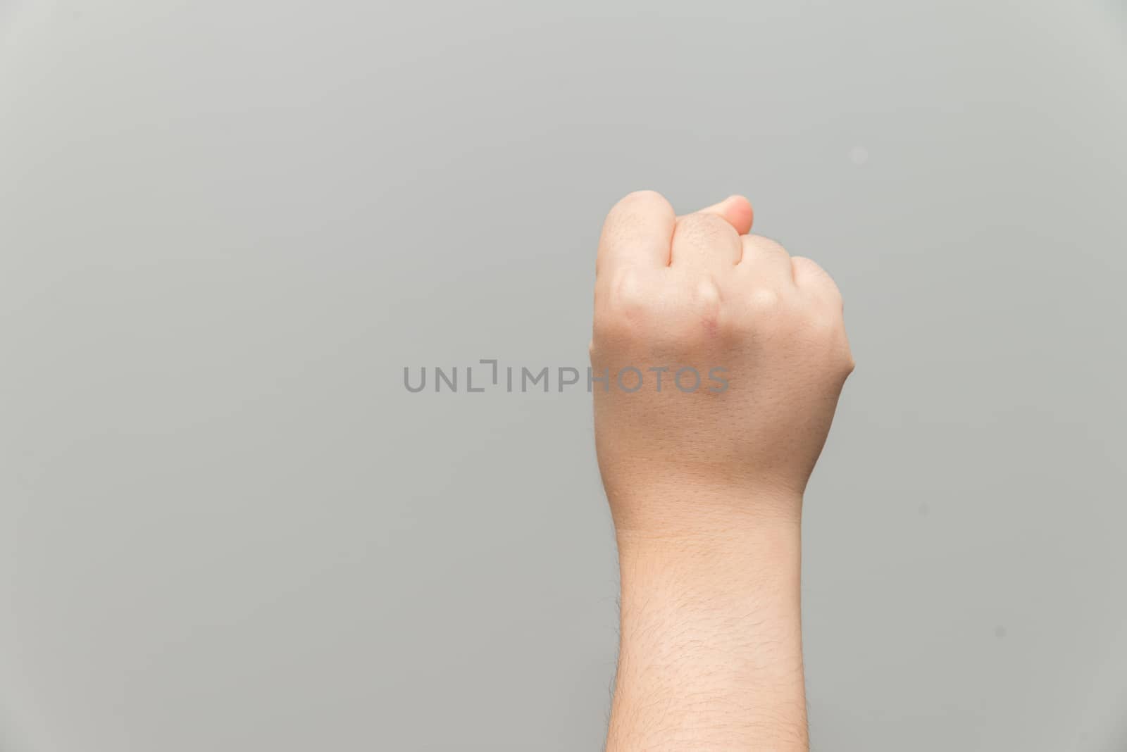 Human hand with closed fist on gray background