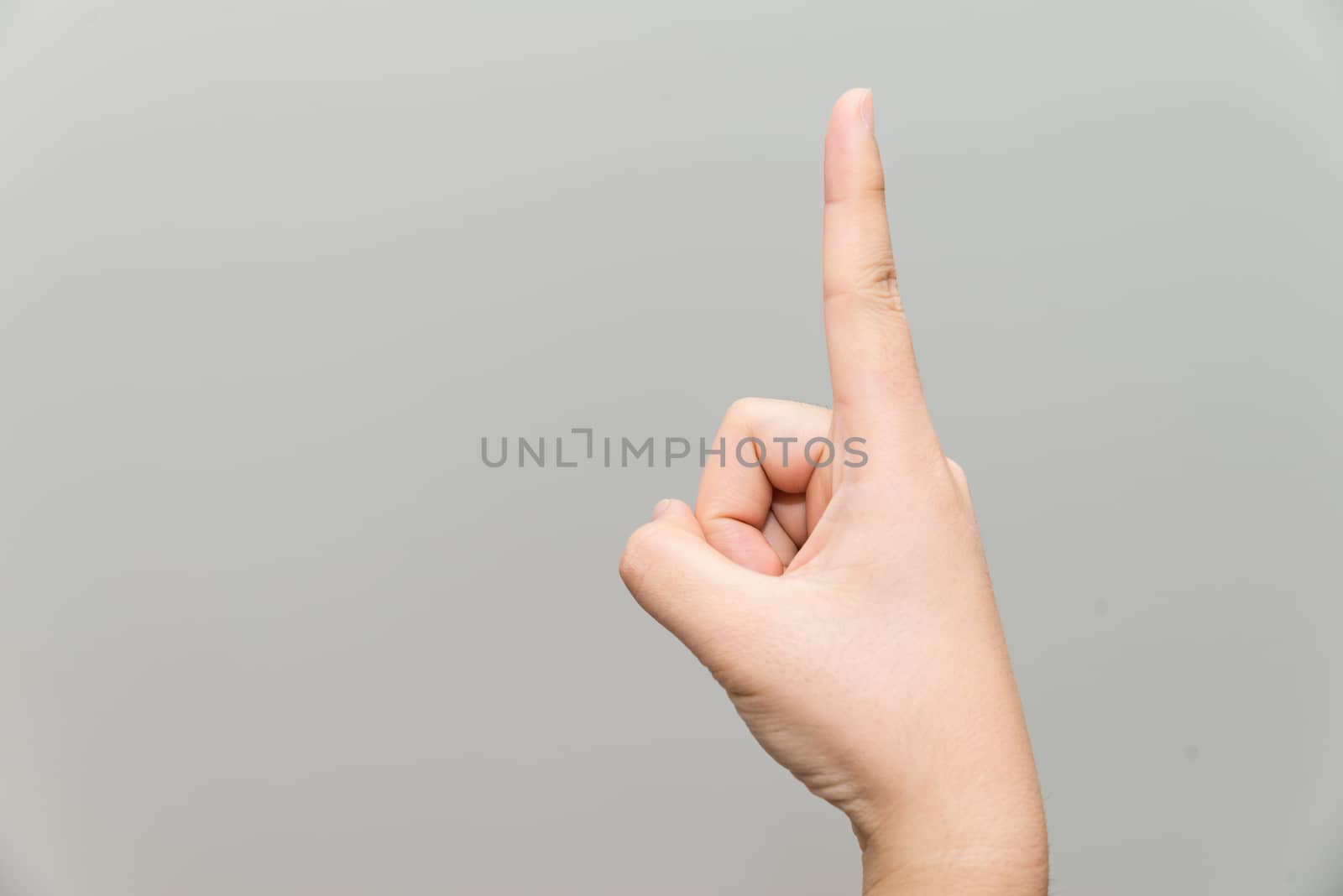 Human hand with one finger sticking up on light gray background