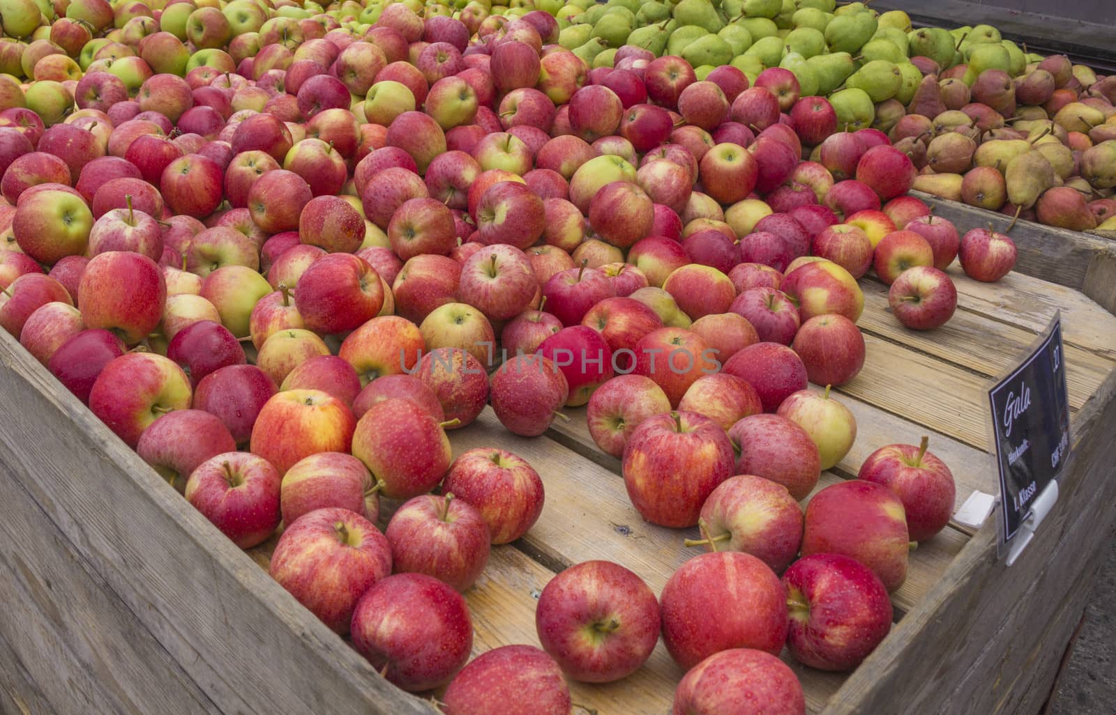 Red apples and pears stand at a local farmer's market