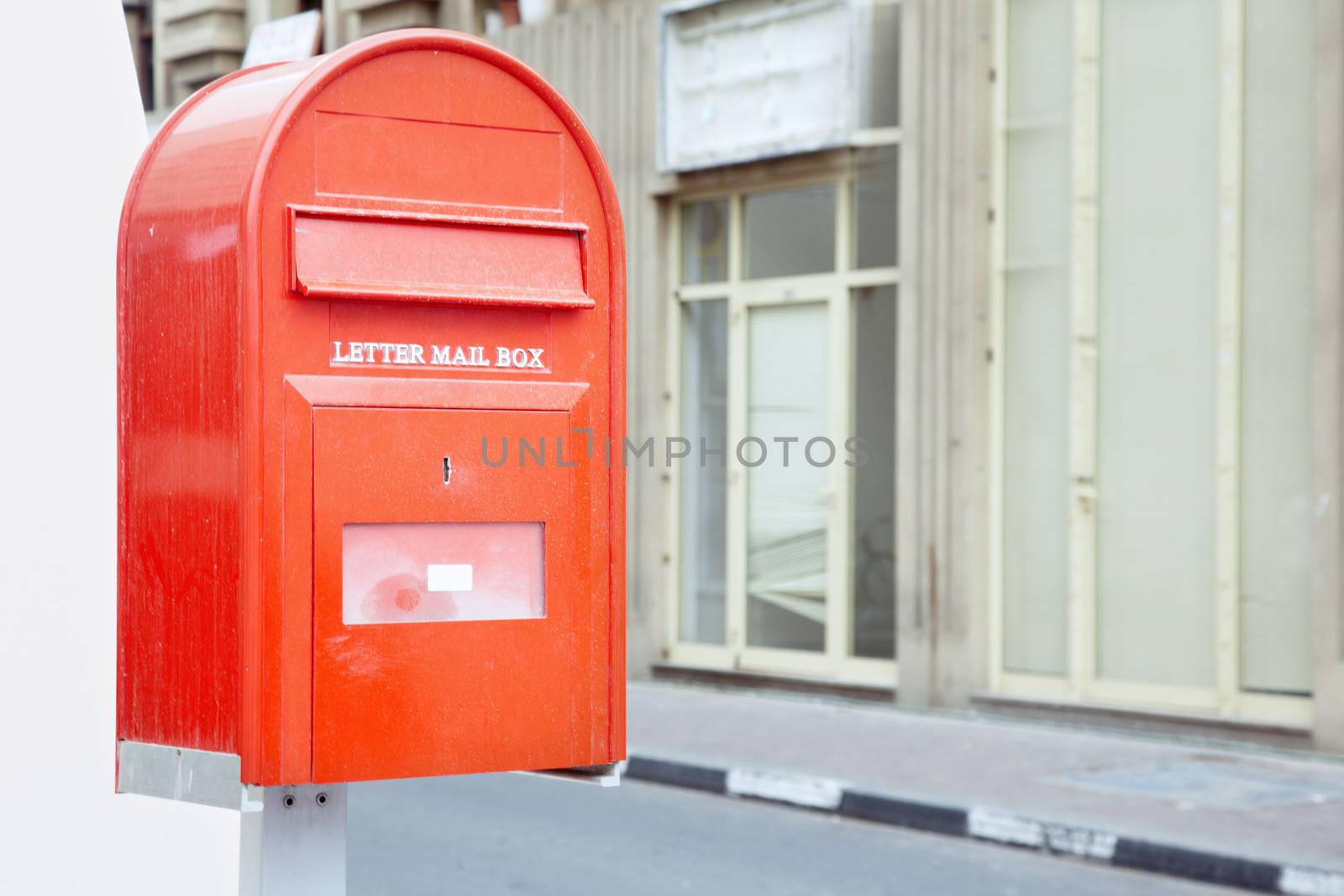 Red mail box outdoors with English text. Horizontal photo