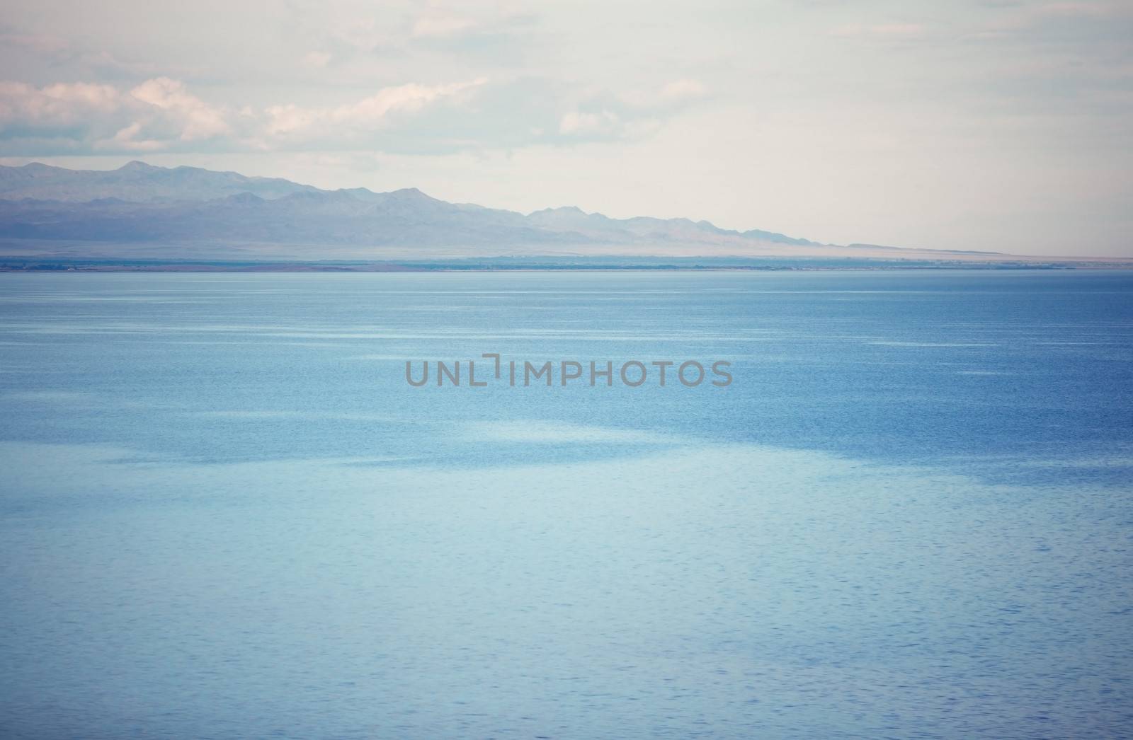 View on the cold lake with mountains on a background