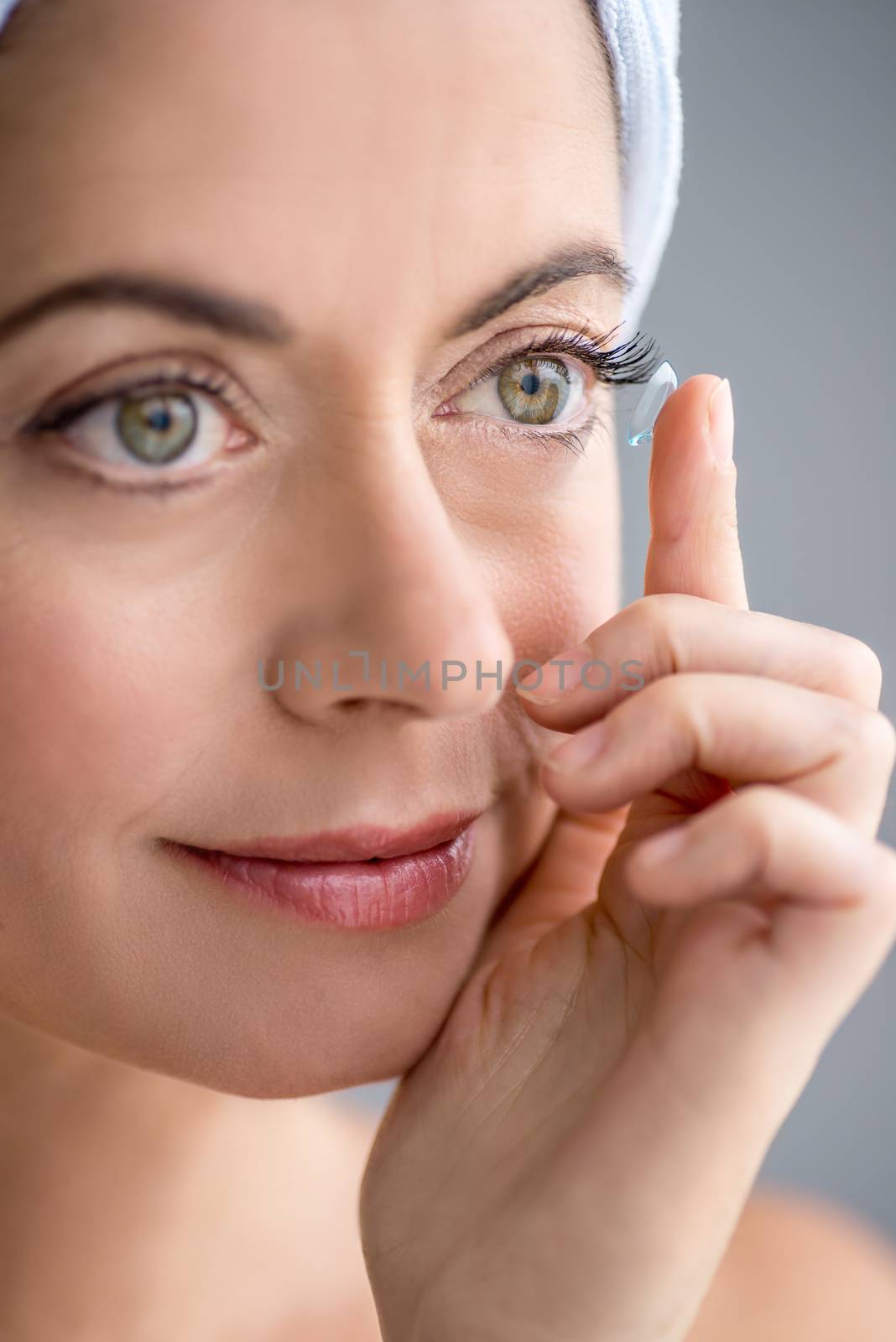 woman in her forties inserting contact lenses by julief514