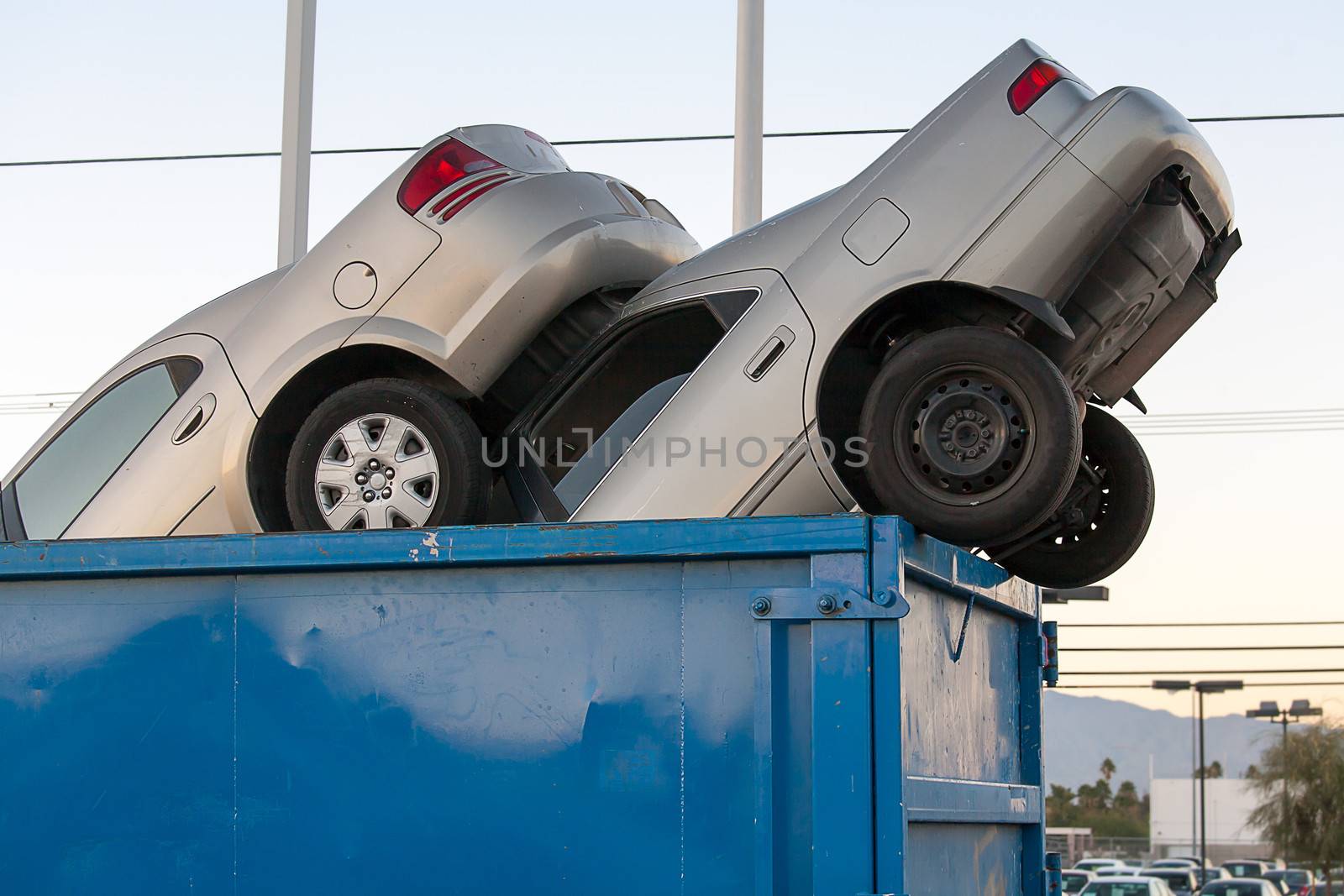 2 junk cars in a dumpster