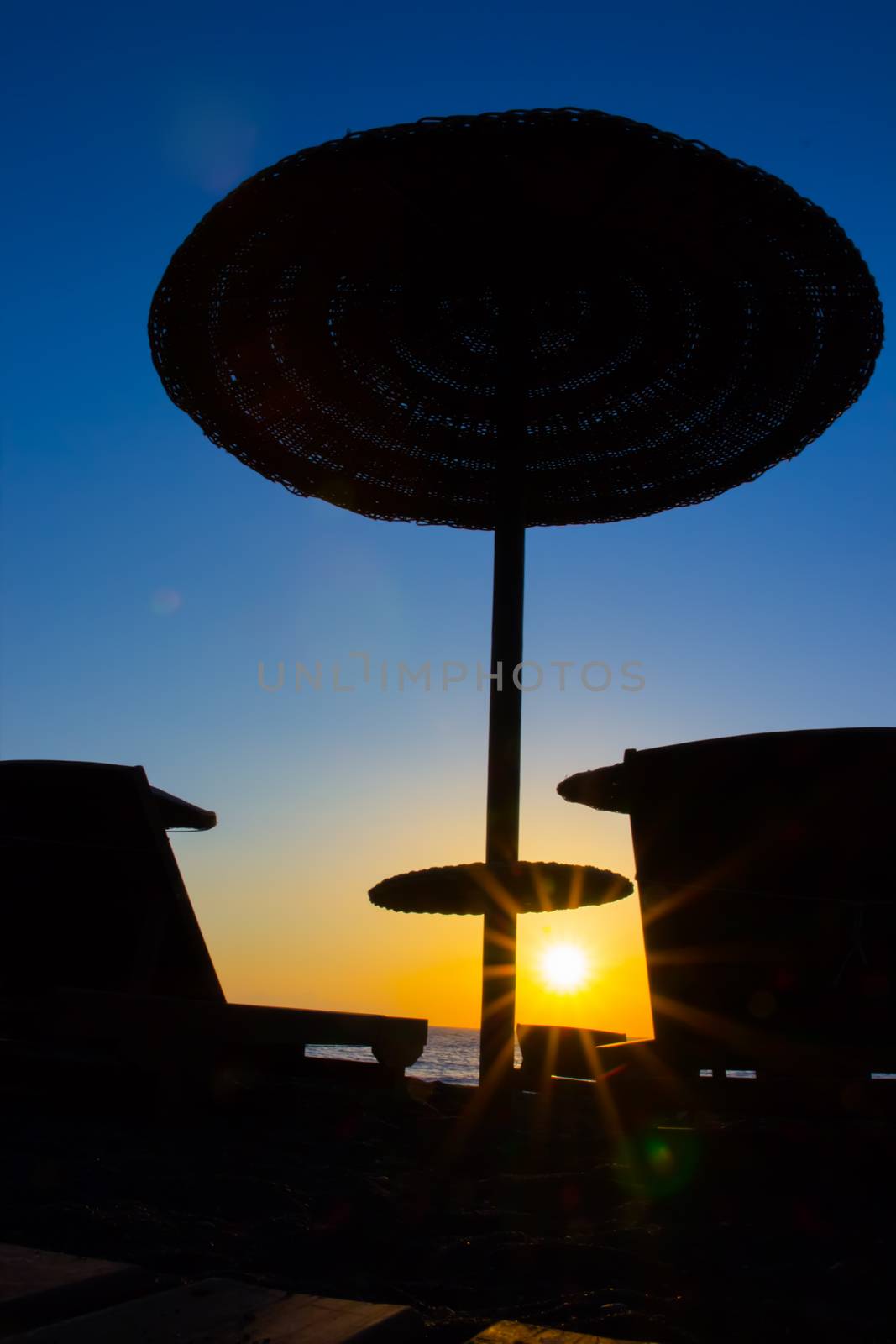 Beach umbrella on the beach at sunset