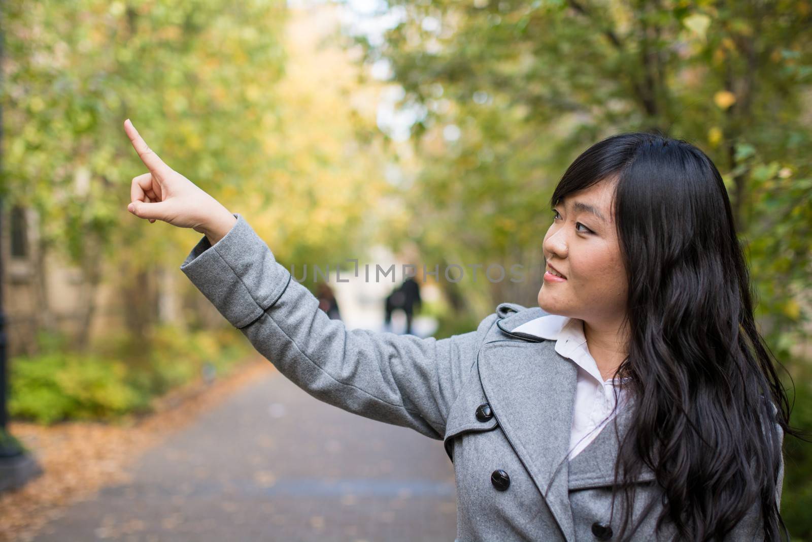 Portrait of woman pointing at something by IVYPHOTOS