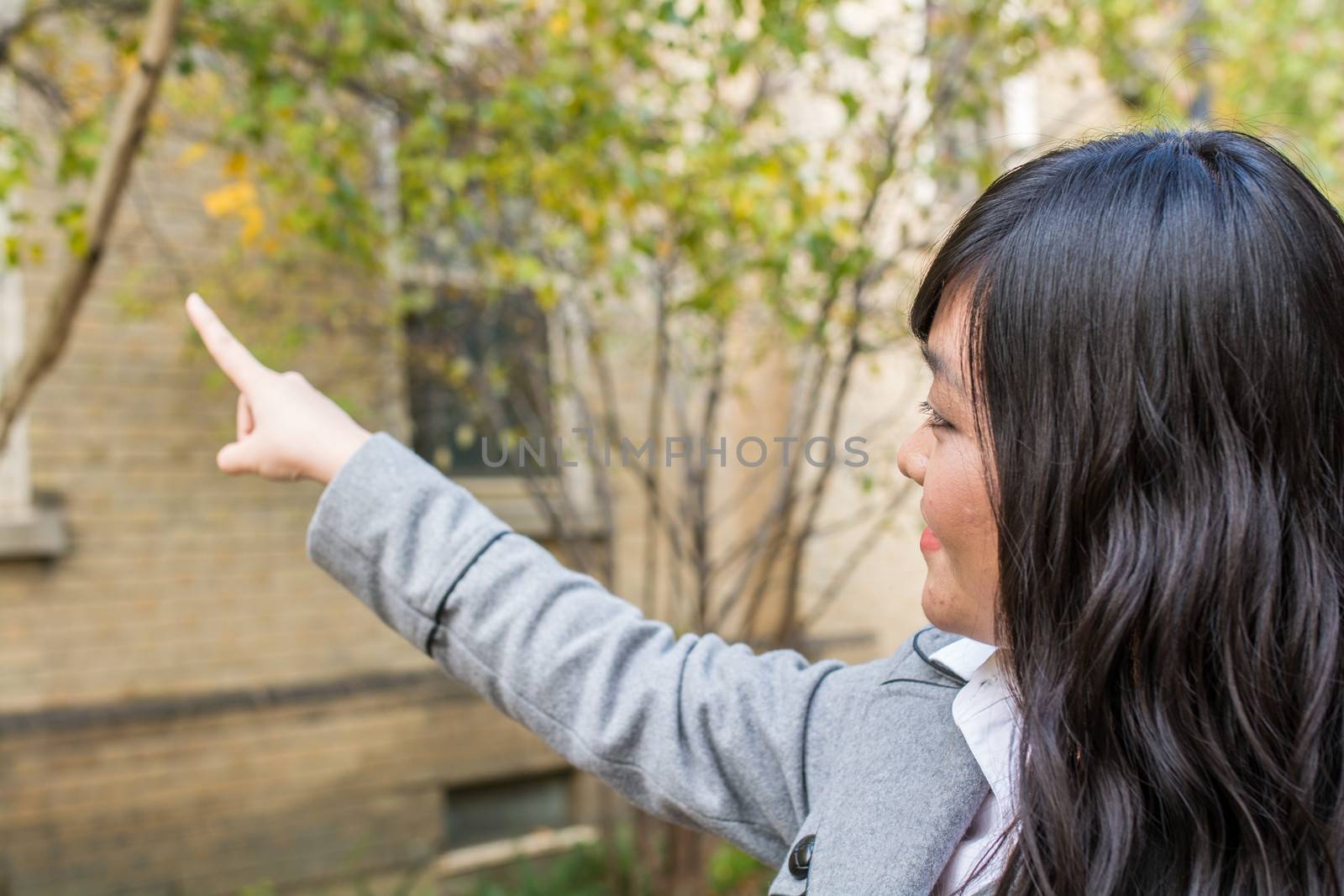 Portrait of woman pointing at something by IVYPHOTOS