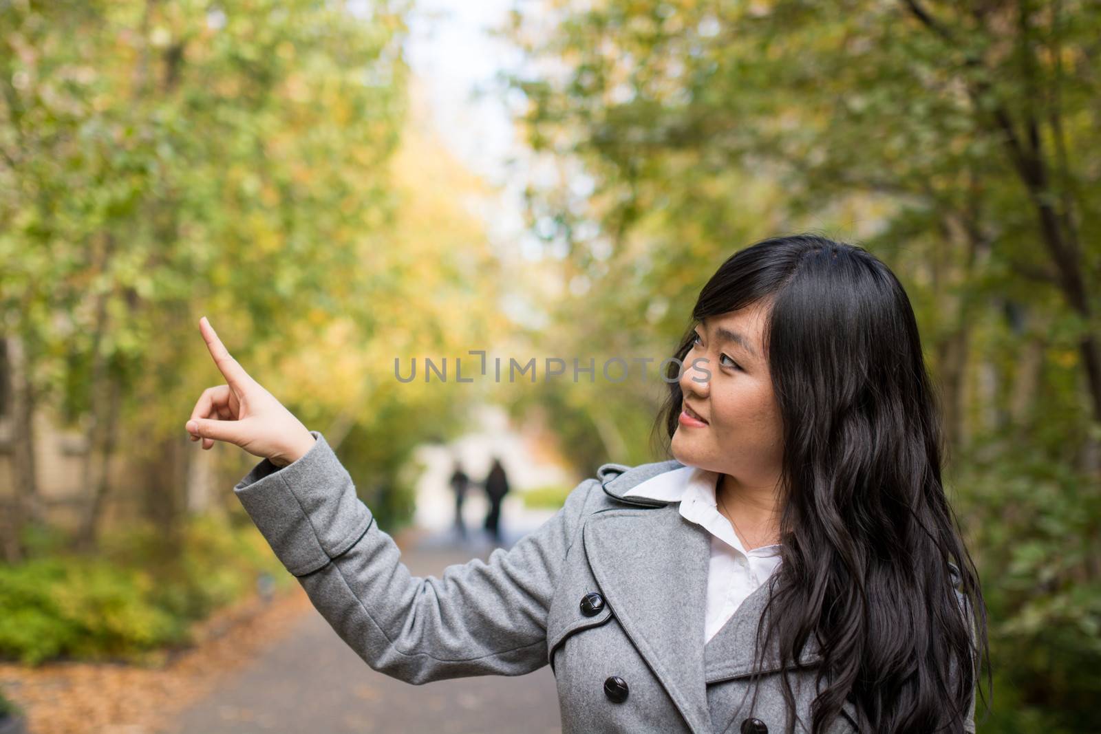 Portrait of woman pointing at something by IVYPHOTOS