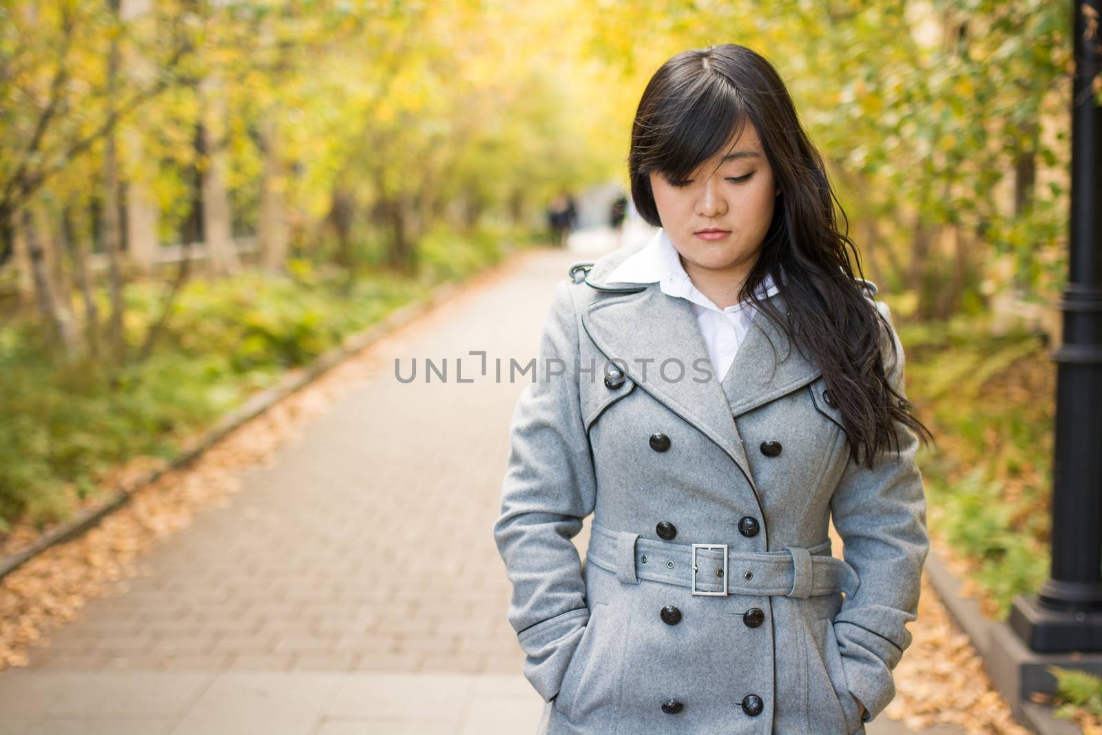 Close up portrait of attractive young girl alone on a road looking depressed