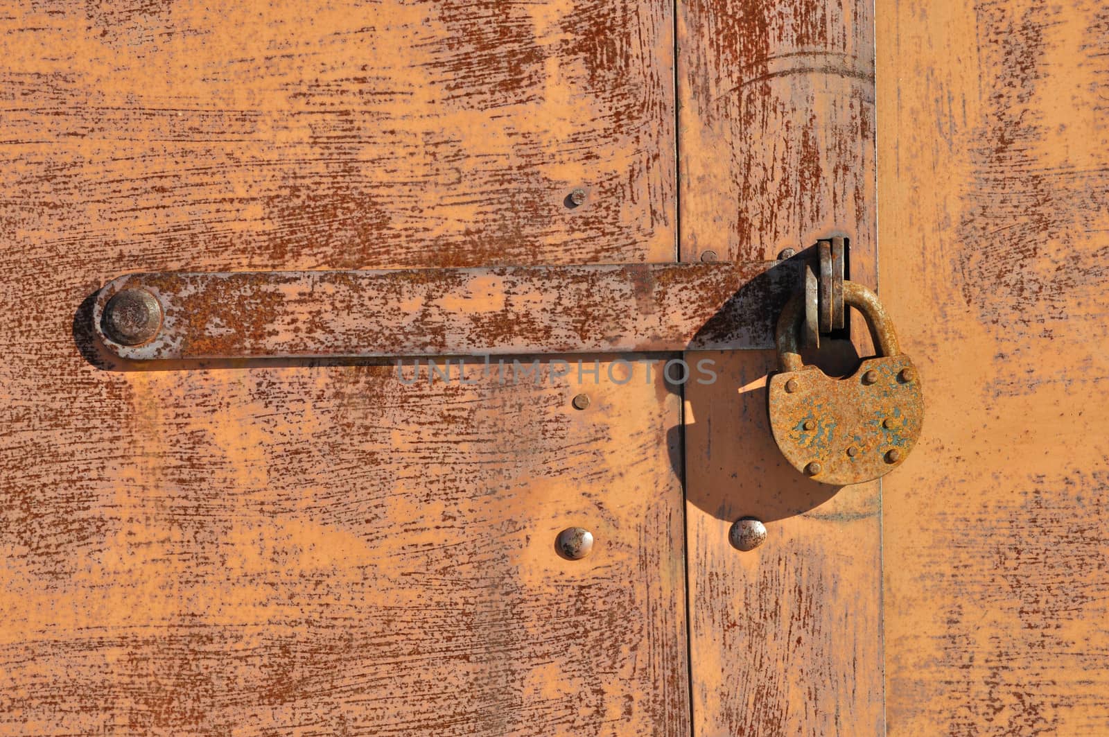 Closeup of old rusty padlock on metal background