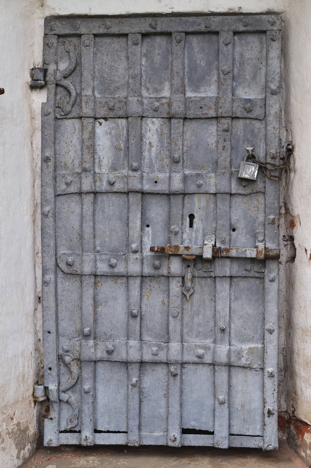 Closeup of ancient rusty iron gate with padlock