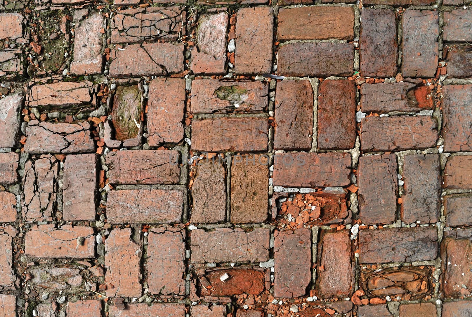 Fragment of old rough red brick pavement surface