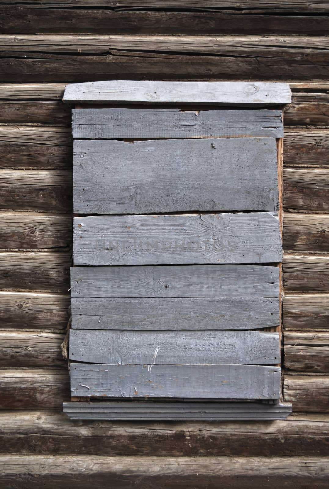 Boarded-up window in a wooden house