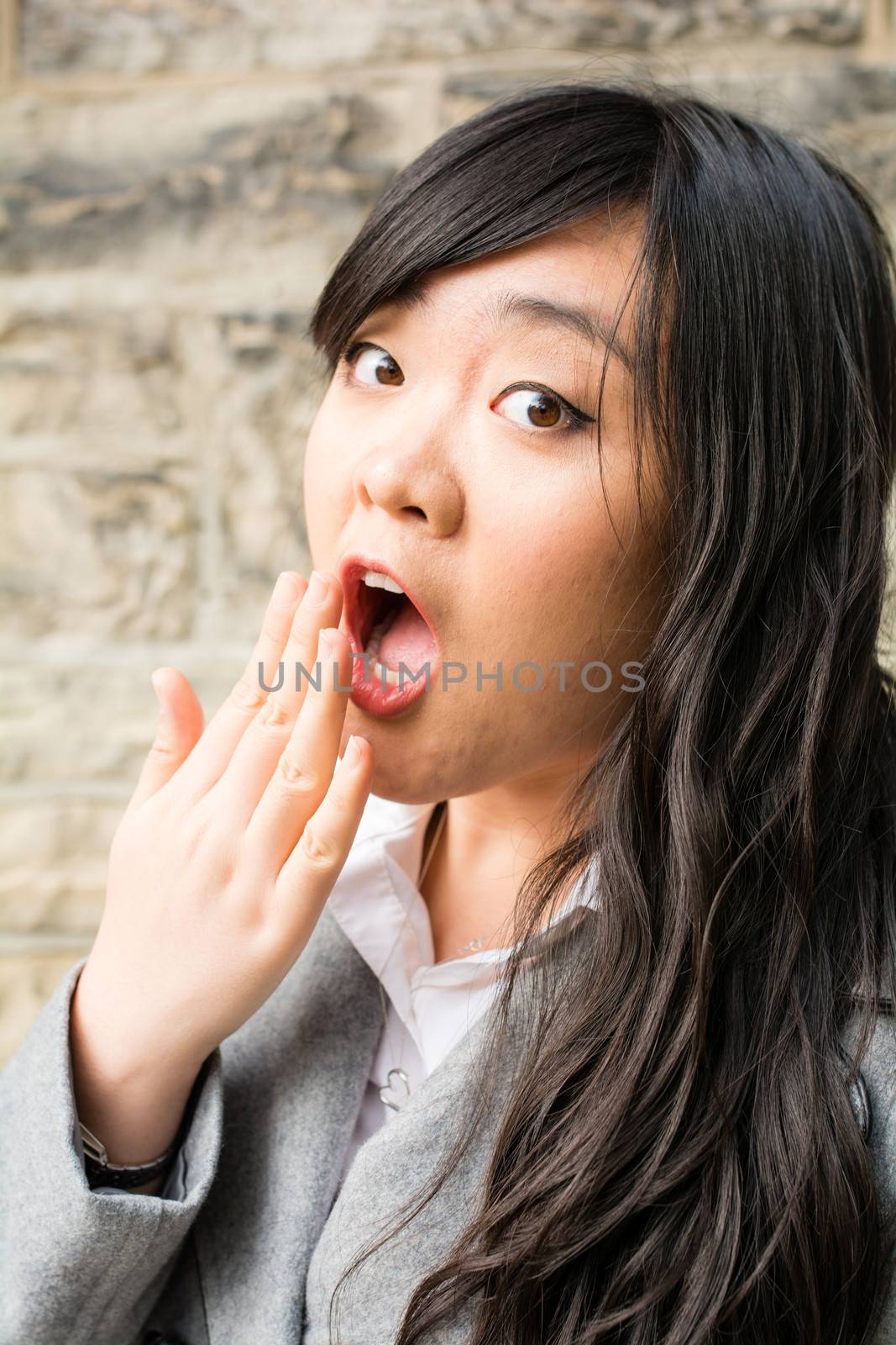 Portrait of attractive young woman looking surprised and screaming out loud and looking cute