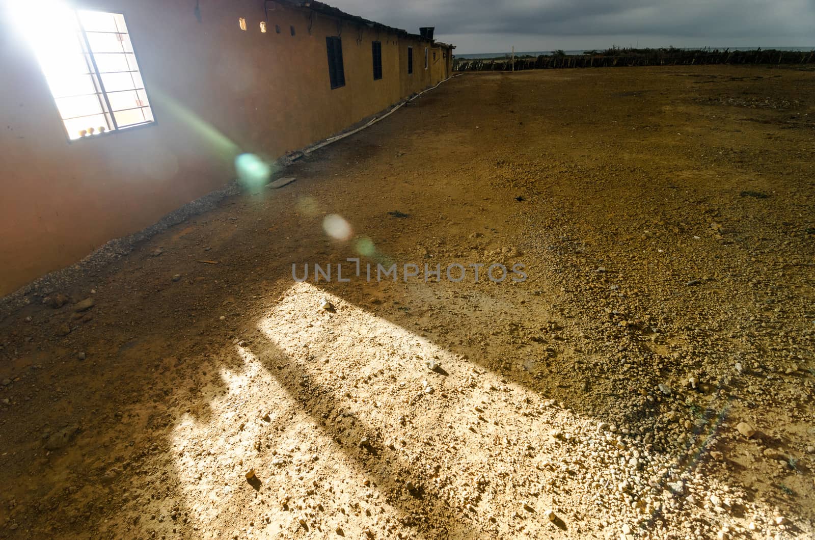 Building in a desert at nighttime with light streaming out of a window