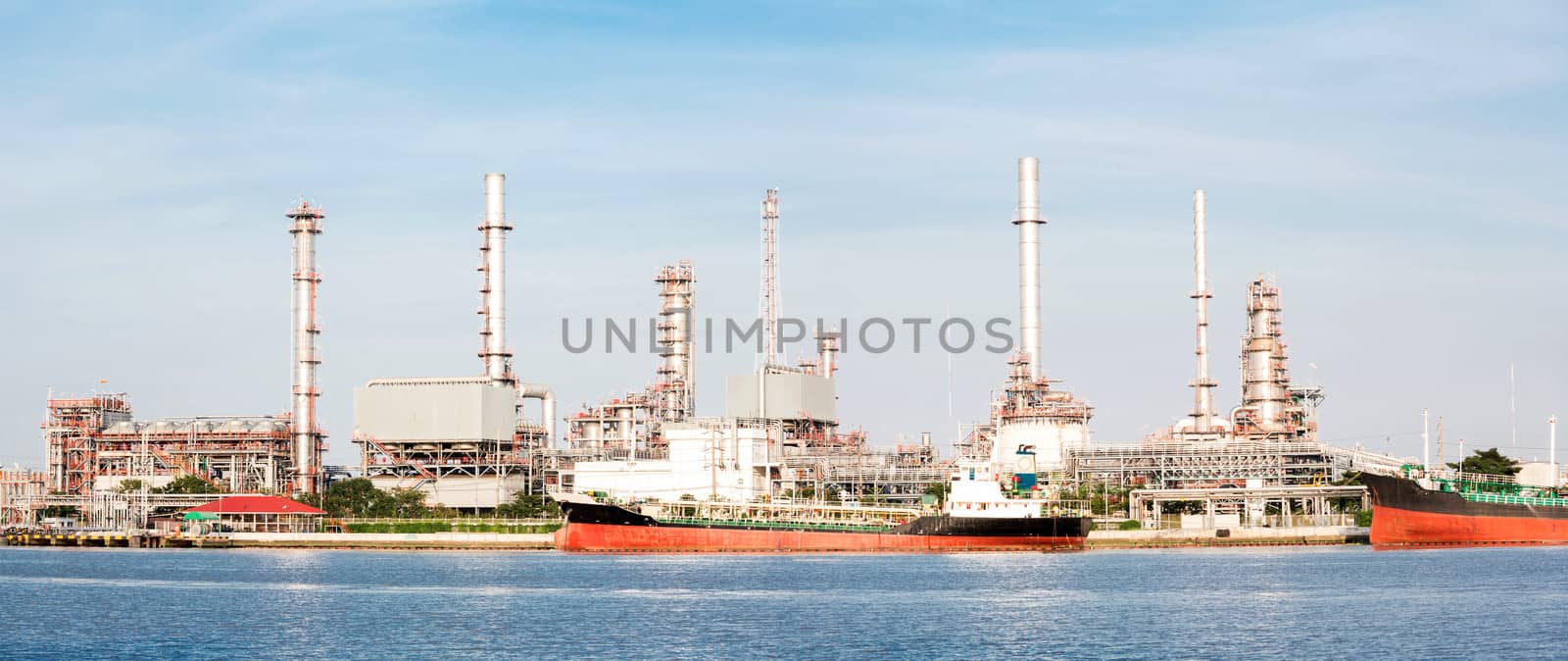 panorama landscape of Oil refinery plant along river with tanker