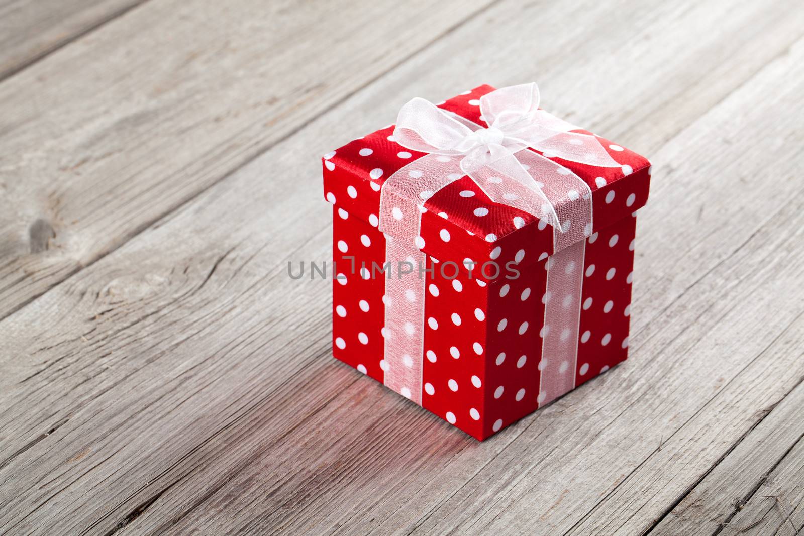 red gift box with  bow on wood background