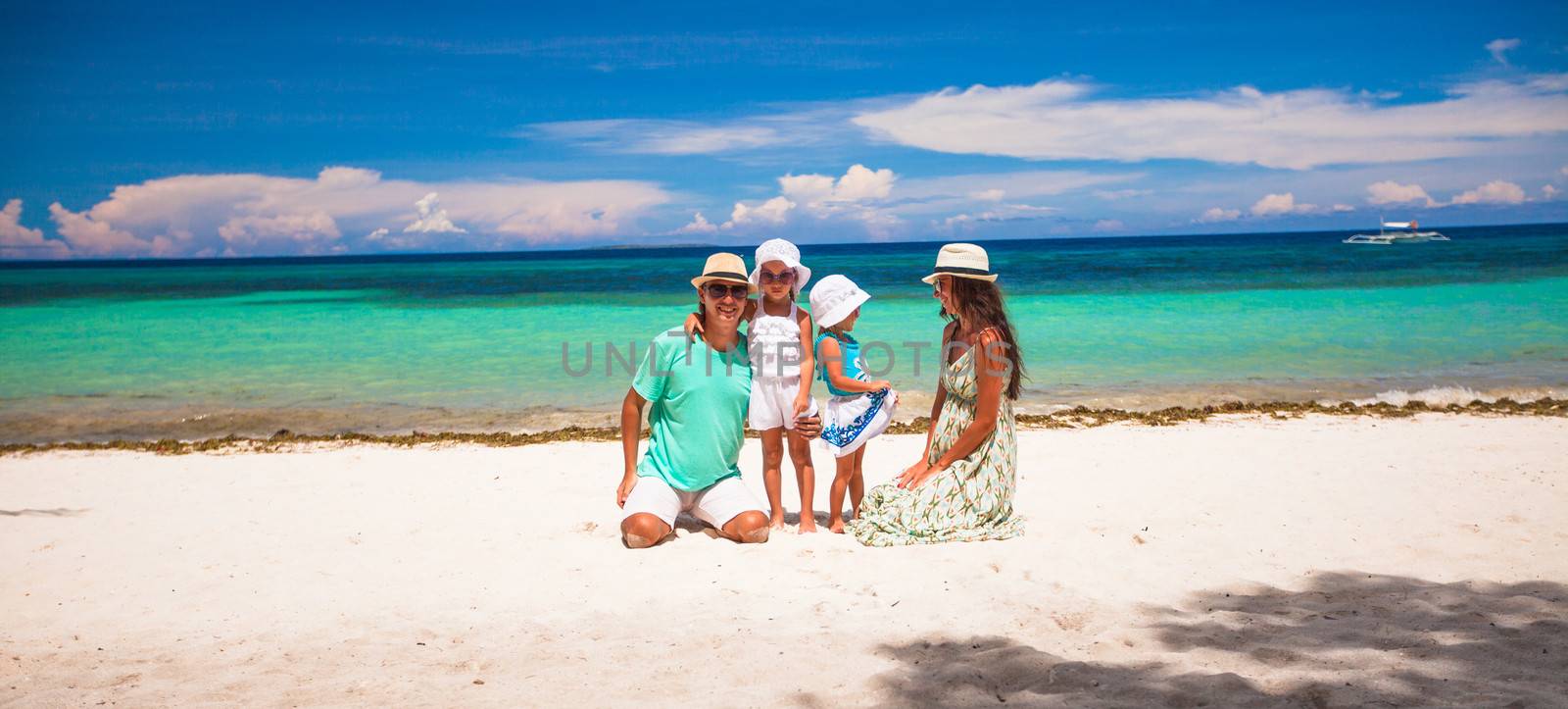 Family of four on beach vacation by travnikovstudio