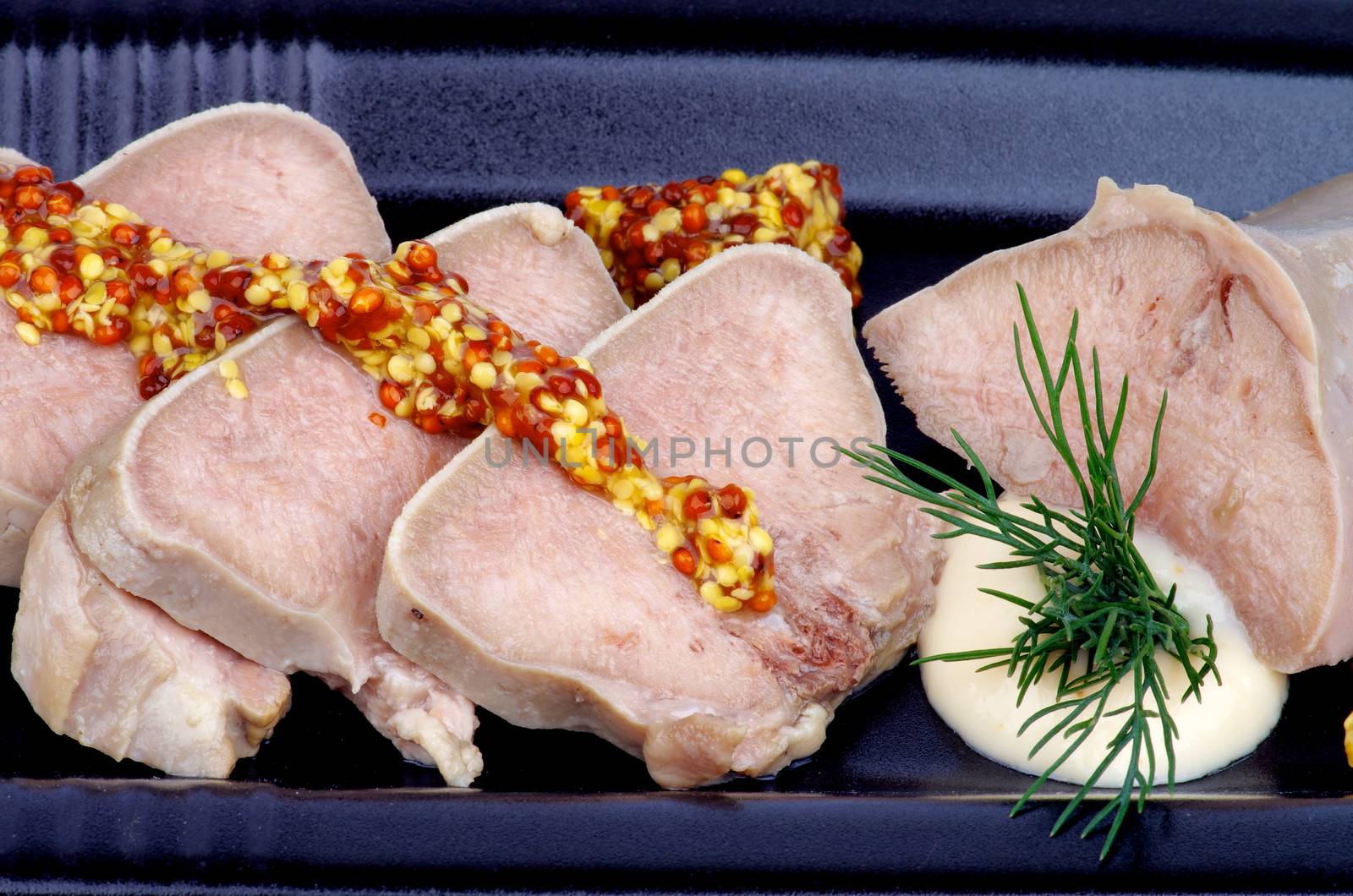 Sliced Boiled Beef Tongue with Whole Grain Mustard, Horseradish and Dill closeup on Black Plate