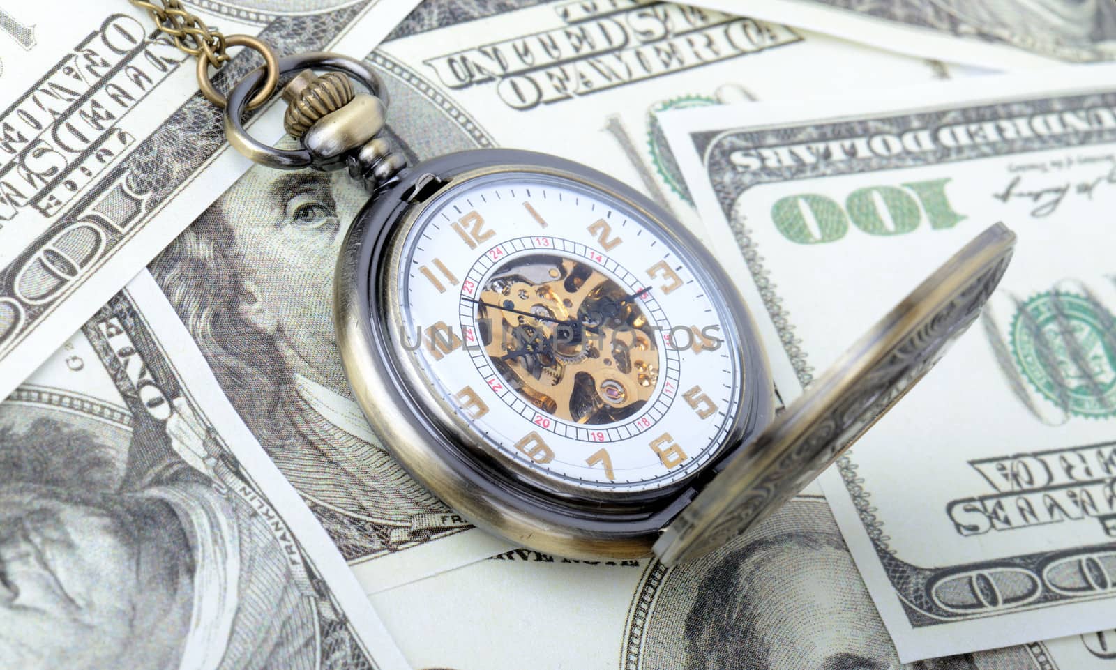 Concept of time is money, old watch on a pile dollar notes