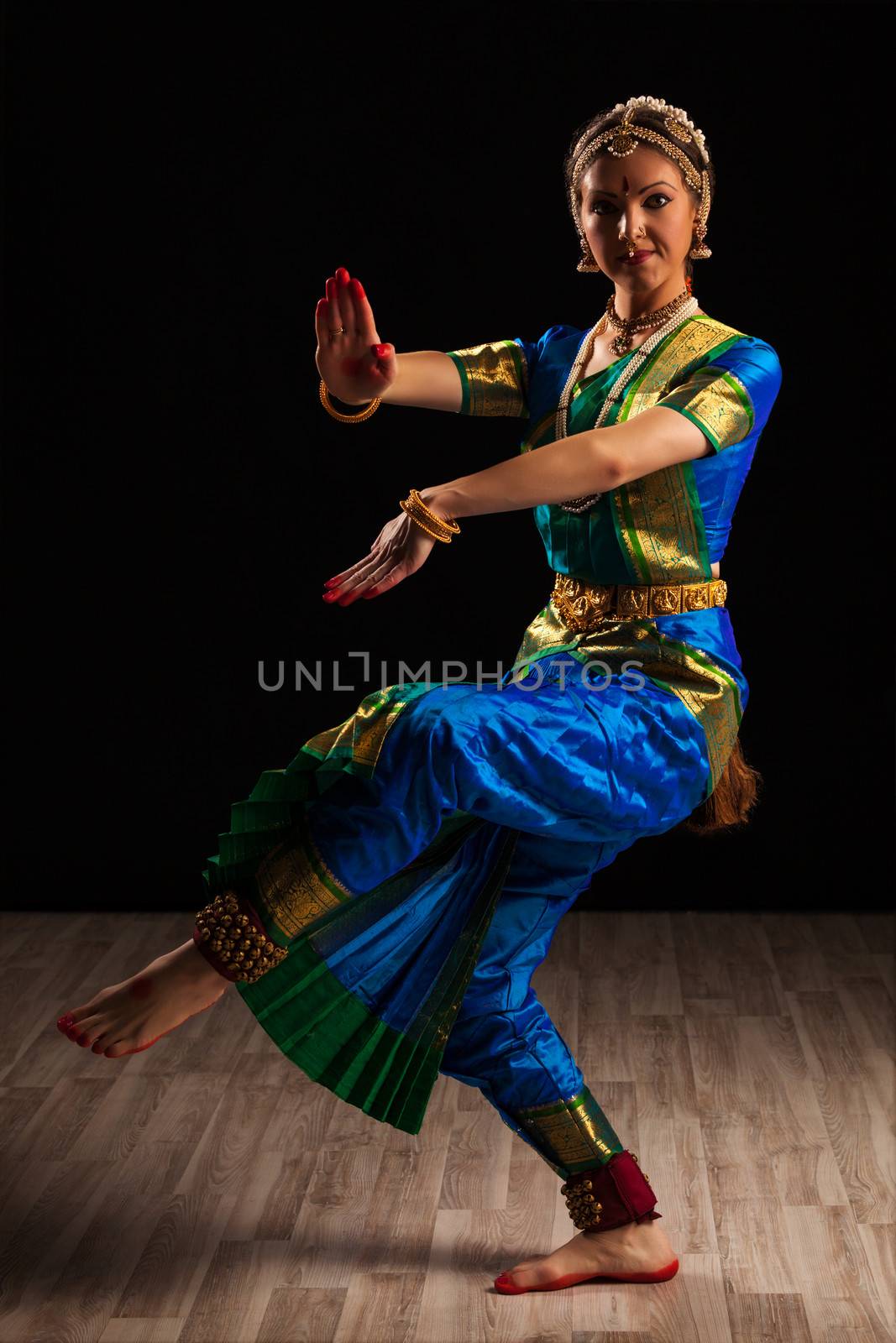 Young beautiful woman dancer exponent of Indian classical dance Bharatanatyam in Shiva pose