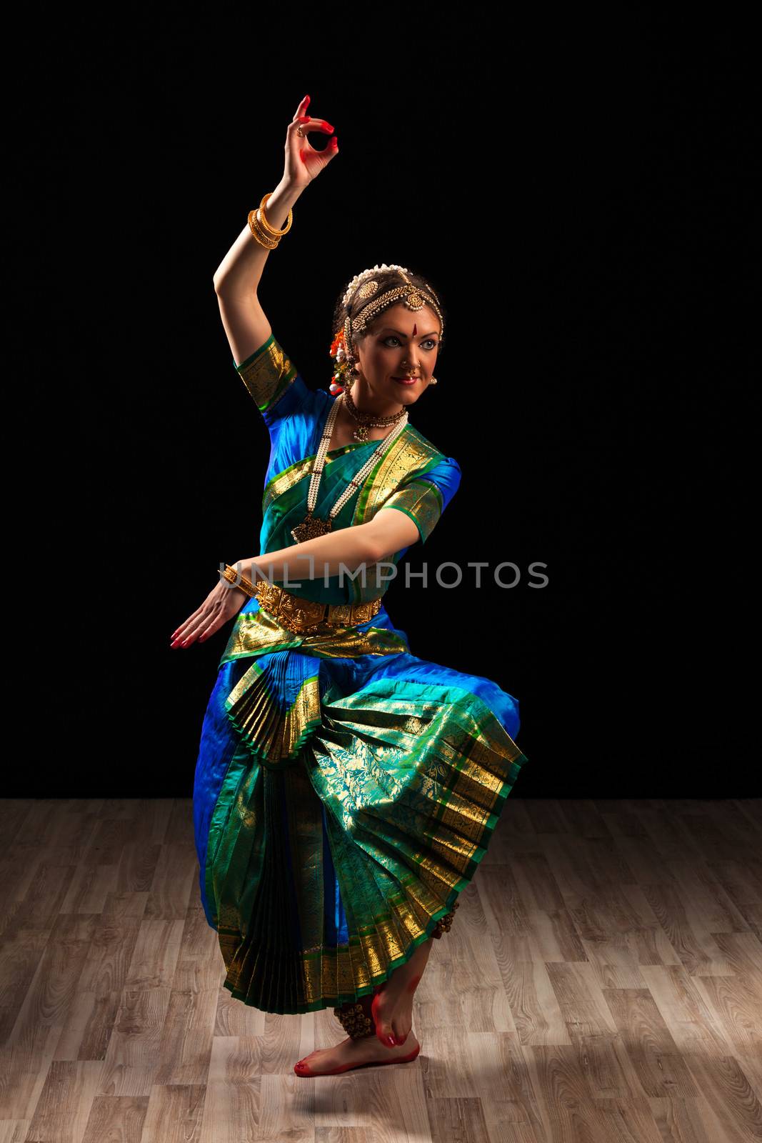 Young beautiful woman dancer exponent of Indian classical dance Bharatanatyam in Shiva pose