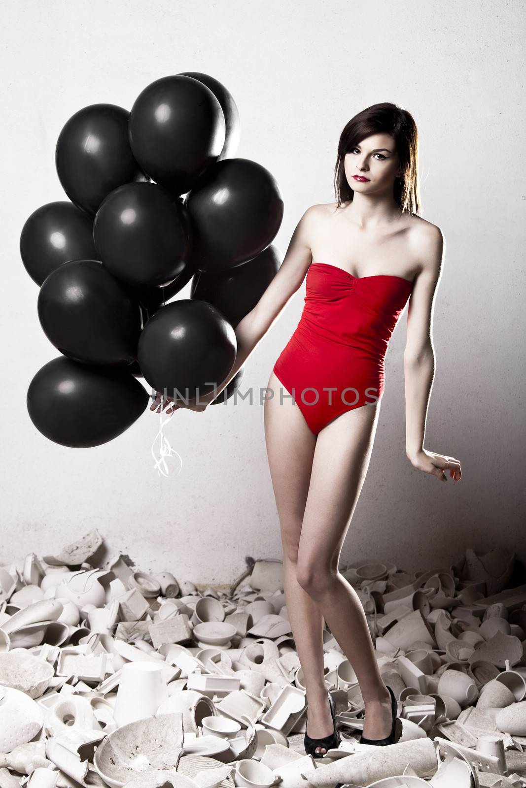 Fashion photoshoot with  a beautiful young woman holding balloons