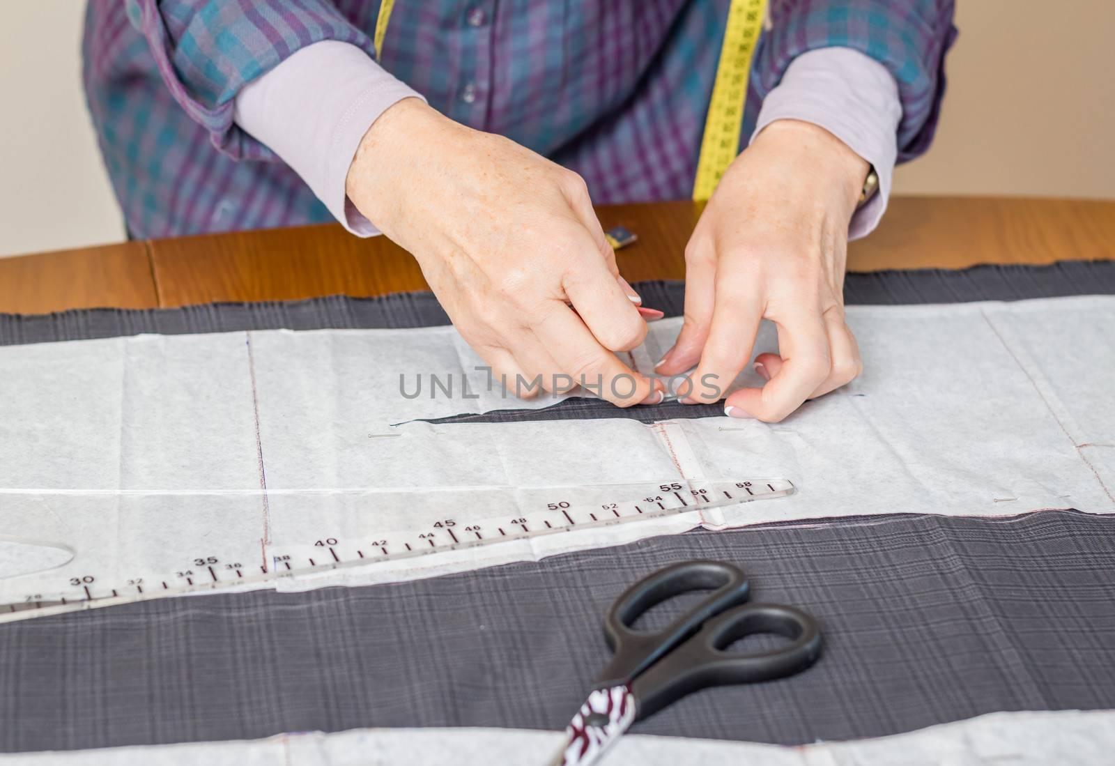 Woman dressmaker design tailor pattern for a suit on the table